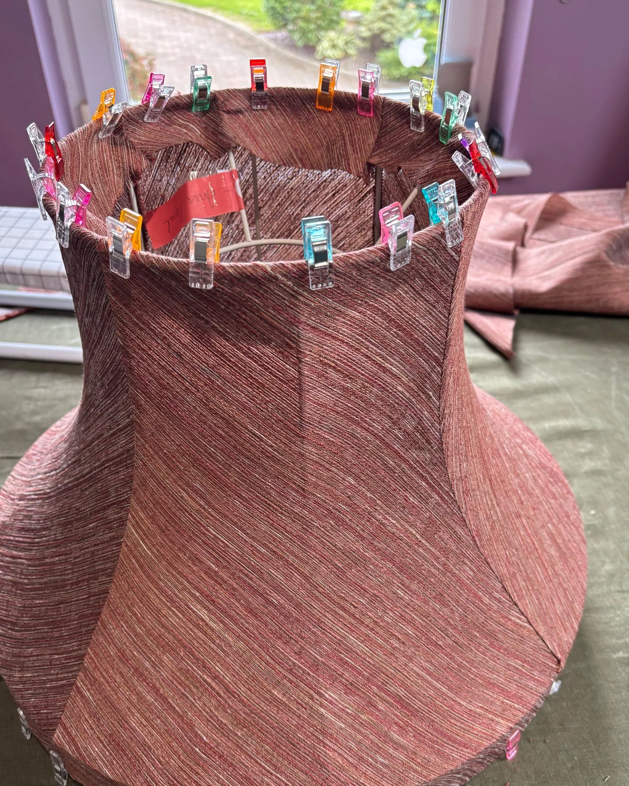 a bespoke hand stitched bowed vintage style lampshade being completed with handmade bias binding trim