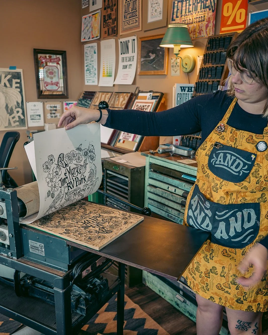 Robin holds up the first print from the carved block, looking for anything that may need refining.
