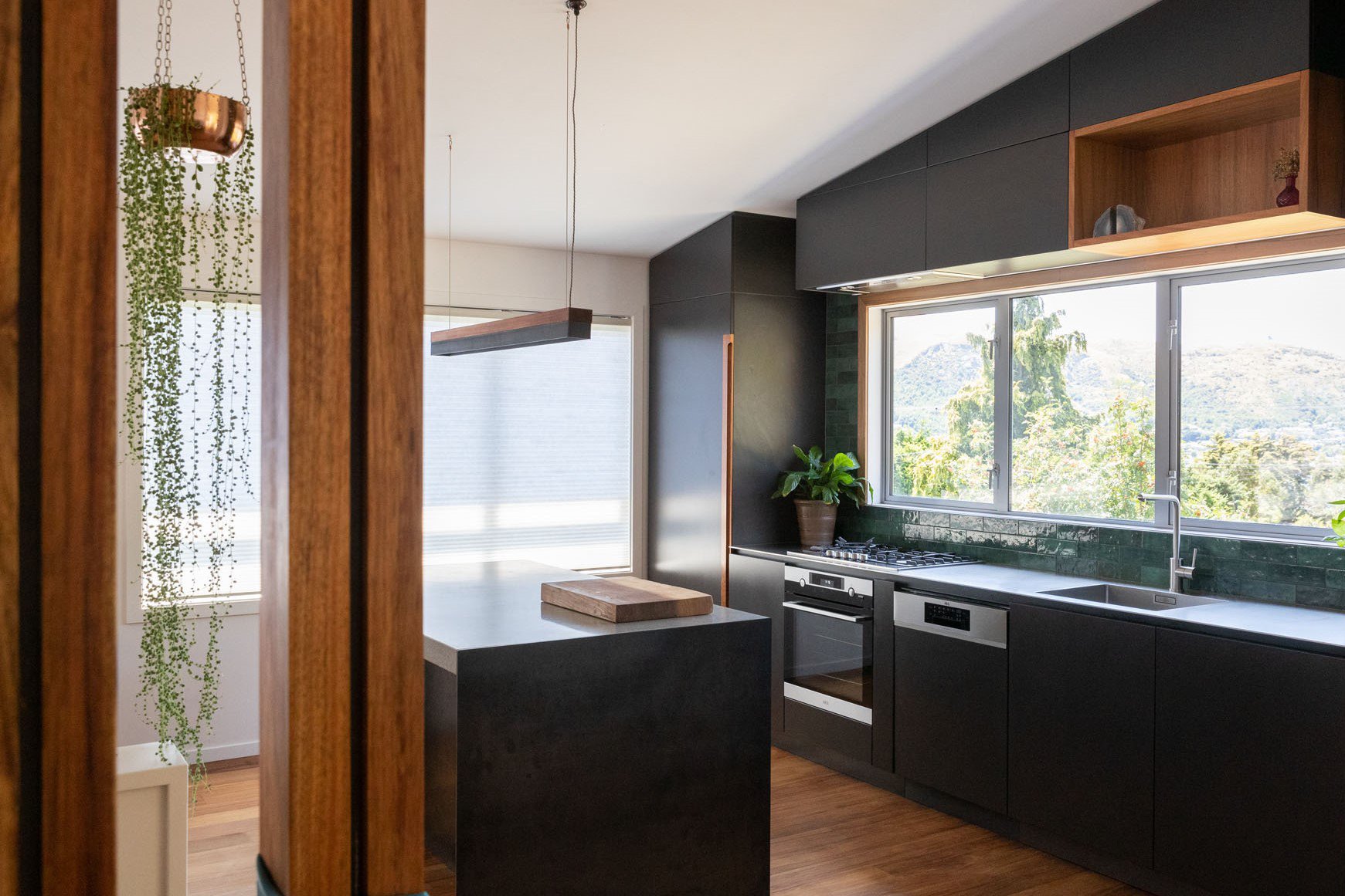 Modern kitchen renovation with concrete bench and dark cabinetry