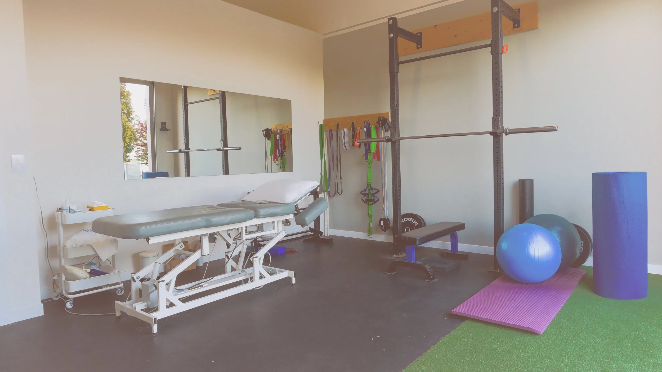 Physiotherapy and rehab space with treatment table, squat rack and resistance bands at Panda Revival Lab