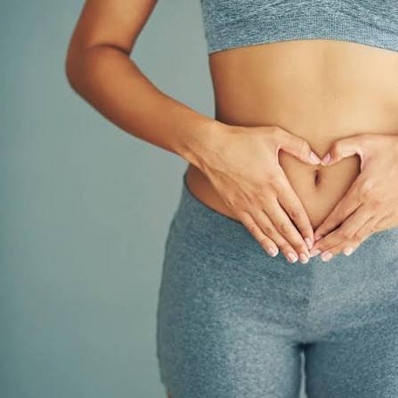 Woman making a heart shape with her hands over her abdomen, representing what to expect from naturopathic hormone care