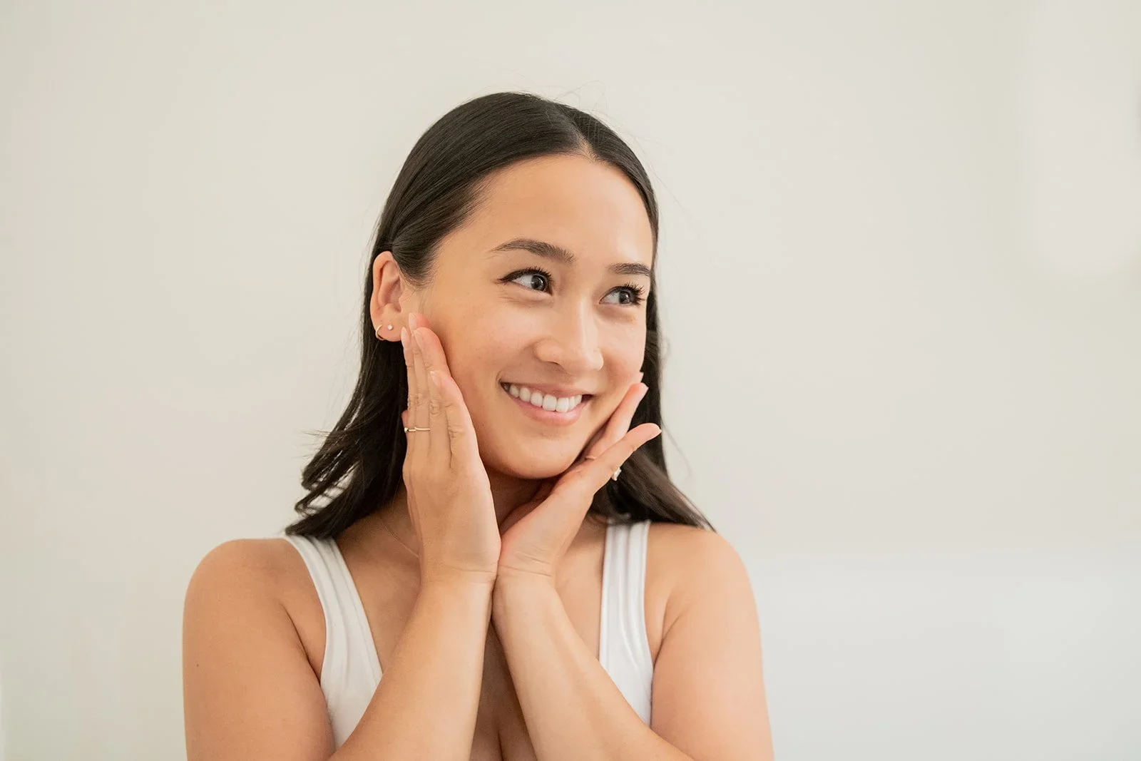 Smiling woman holding her jaw after TMJ massage for jaw pain relief in Surrey, BC
