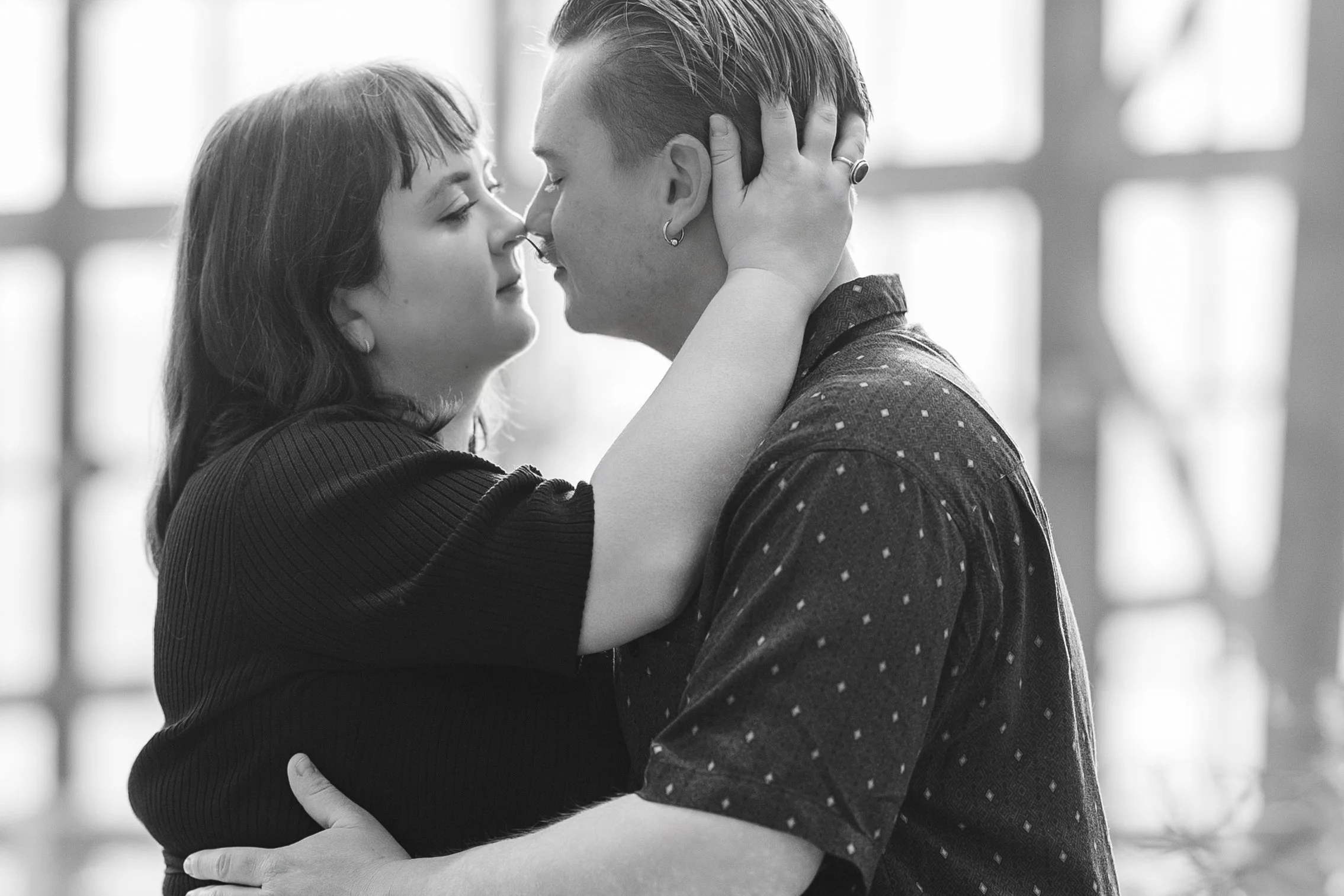 black and white photography of a couple inches apart, about to kiss. they are sharing an  intimate engagement photo session at the Conservatory at Lauritzen Gardens in Omaha, NE.