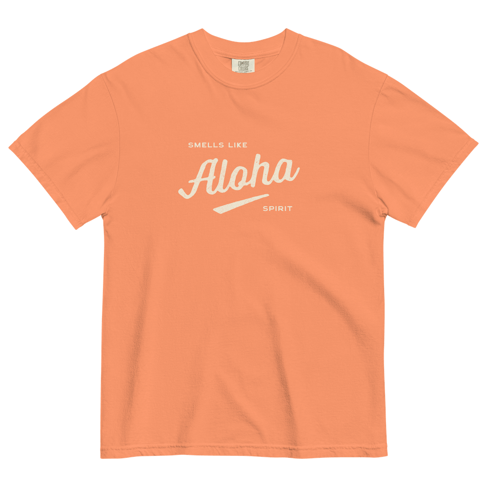 The front of a muted orange graphic teeshirt printed with “Smells Like Aloha Spirit” in creamy vanilla script.