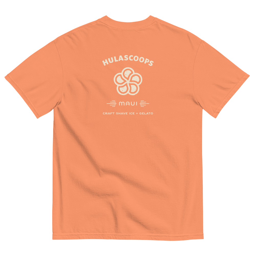 The back of a soft orange teeshirt printed with the HulaScoops name, flower mark, and “Maui” above the text “Craft Shave Ice and Gelato)” in creamy vanilla type.