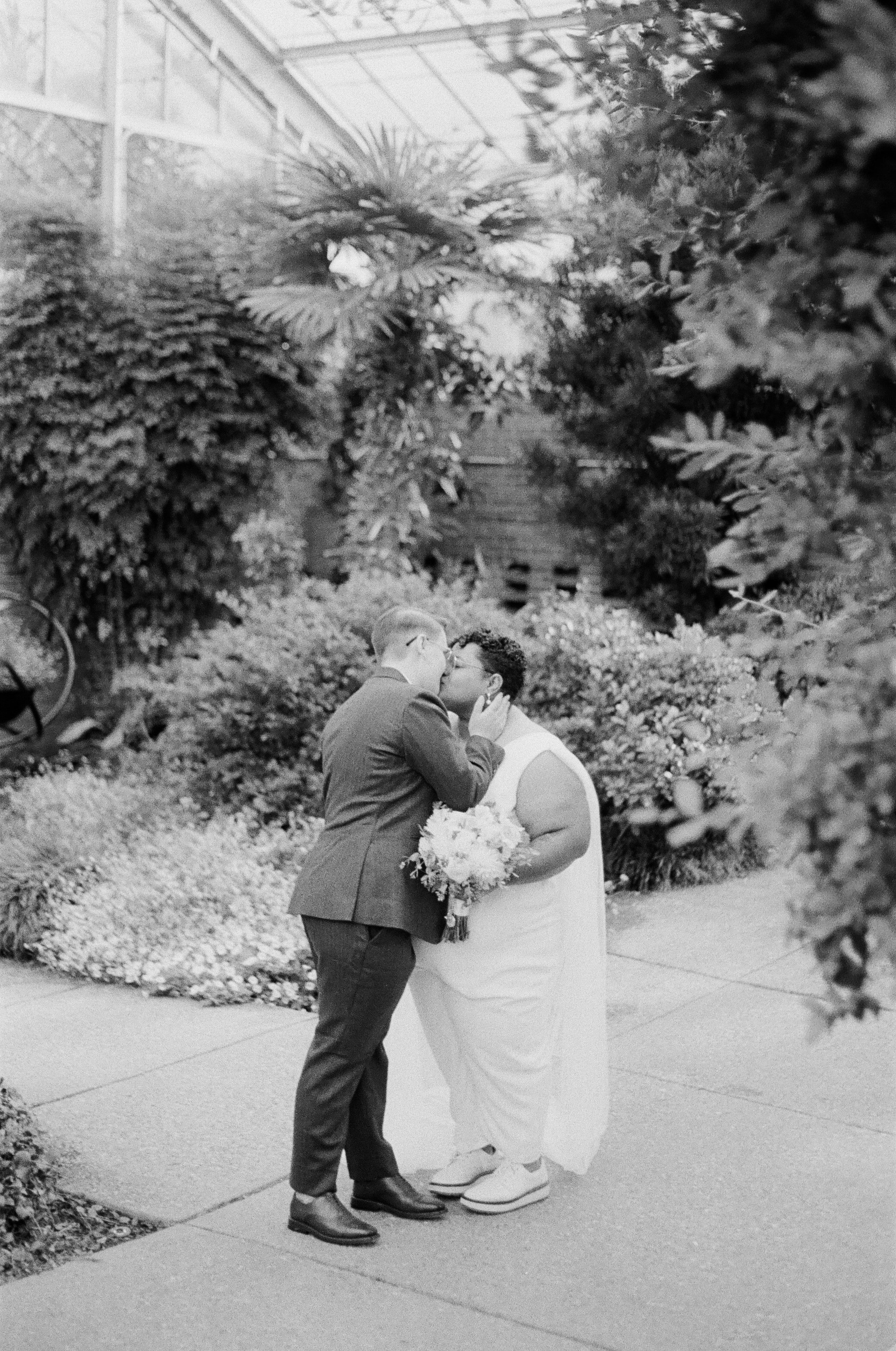 Portrait of queer couple kissing inside Matthaei Botanical Gardens in Ann Arbor - 35mm film