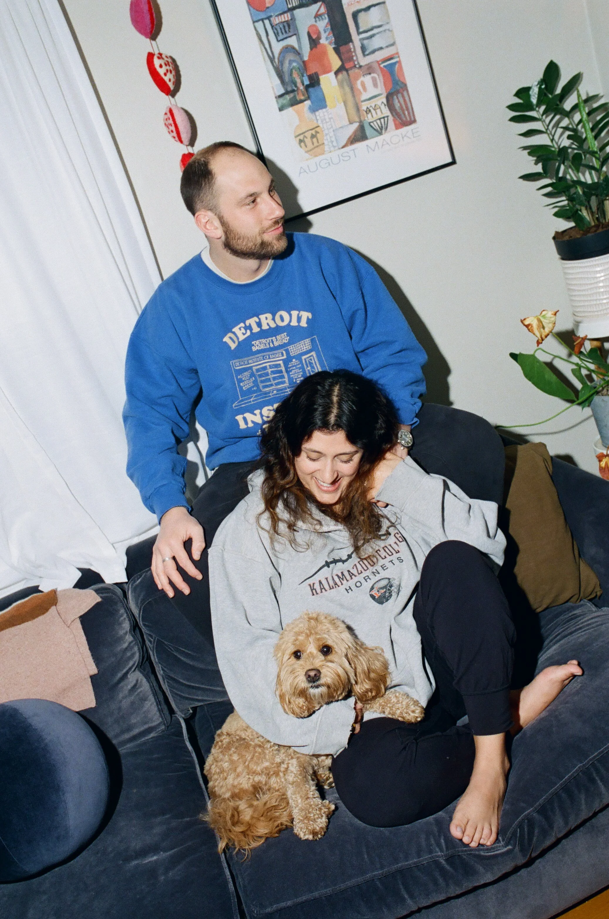 Engagement photo on film of a couple at home with their dog in Metro Detroit