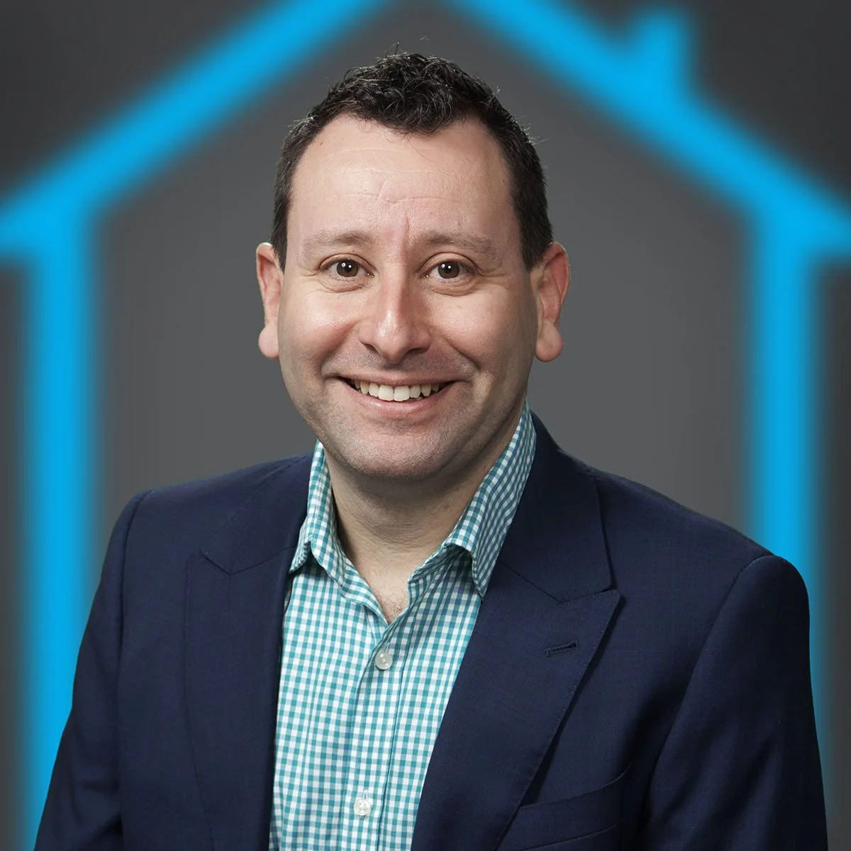 Portrait of a smiling man wearing a dark blazer and green checkered shirt against a dark background with a blue neon hexagon outline.