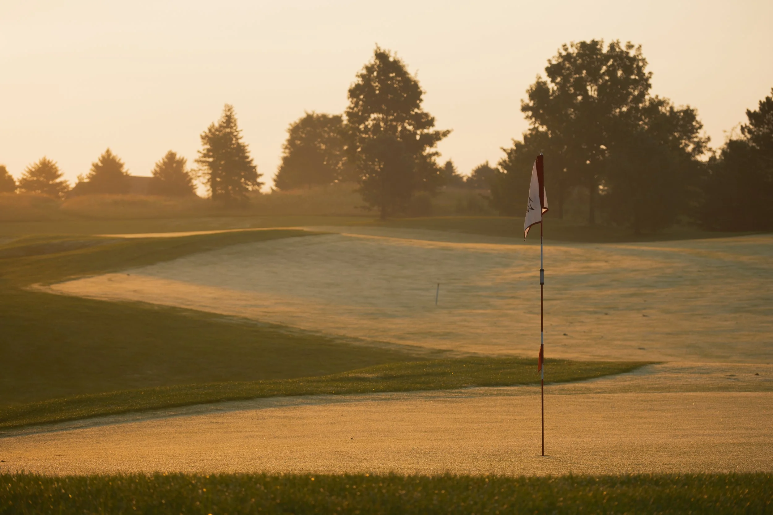 Applecross Country Club in Downingtown, Pennsylvania.  Morning haze rises above the golf course at sunrise. 