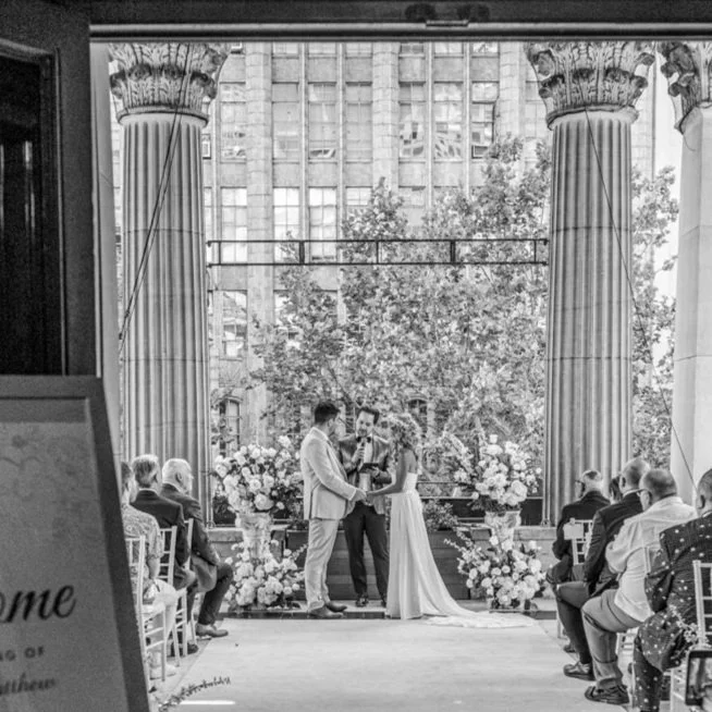 Couple and celebrant standing between large columns