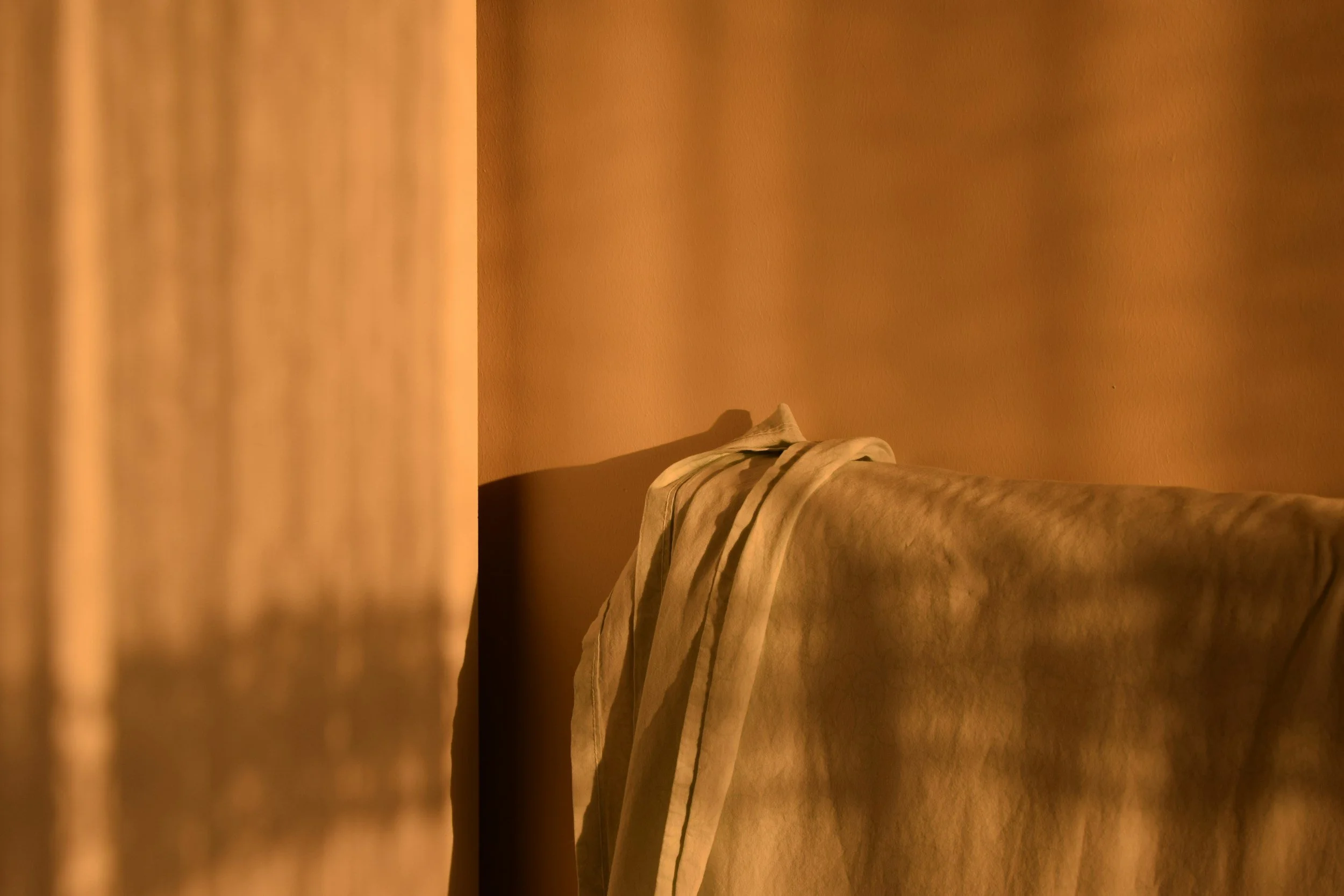 Close-up of beige and cream-colored folded fabric or blanket on a bed.