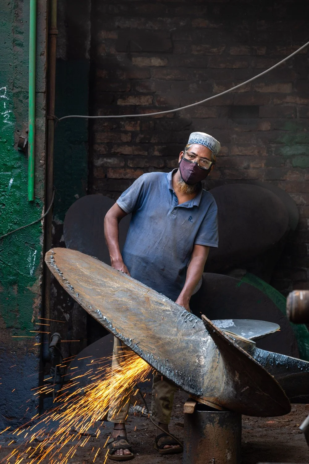 A worker grinding a propeller in a shipyard in Dhaka, Bangladesh. 