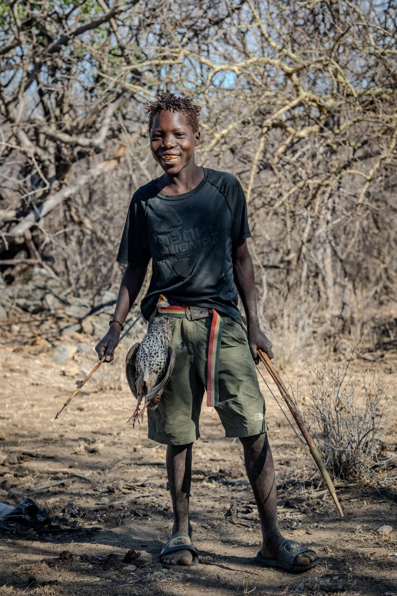 A hadzabe hunter in Tanzania with a fresh kill around his belt. 