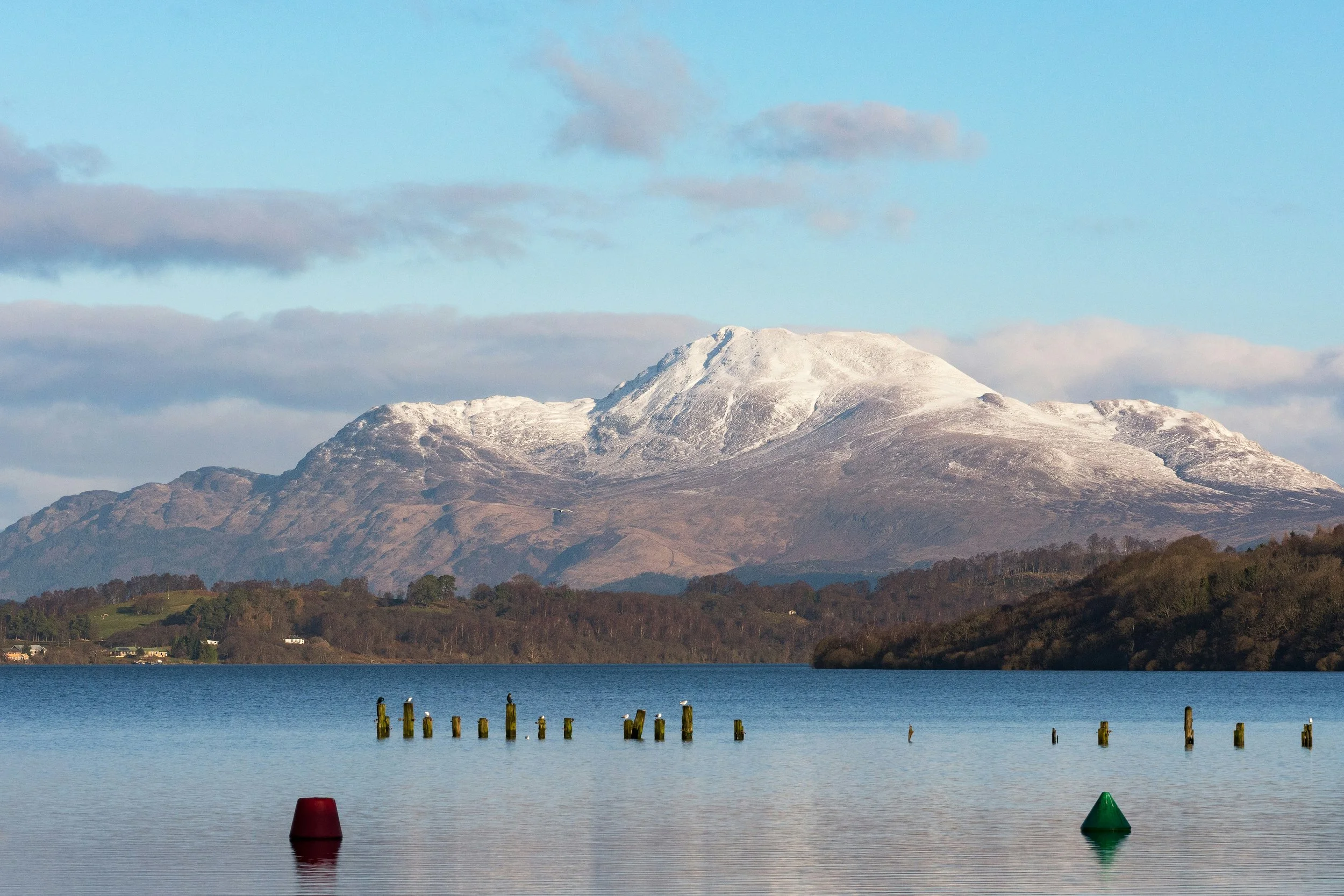 Loch Lomond with snow-capped mountains in the background, showcasing Scotland’s stunning natural beauty.