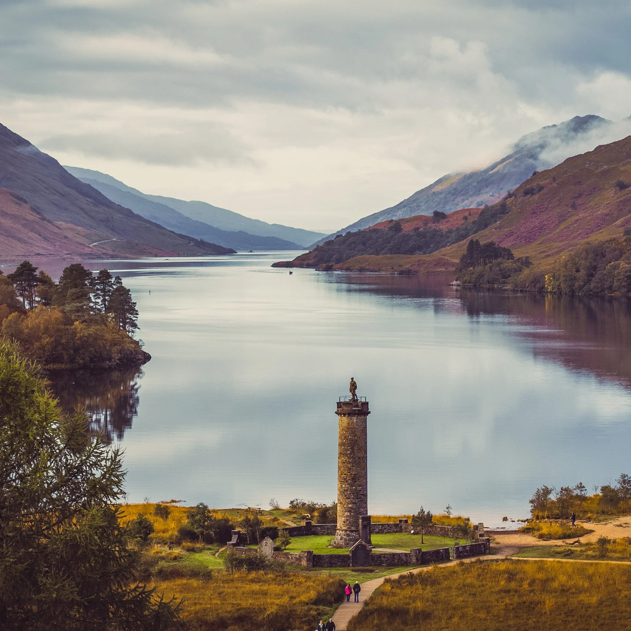 60 foot stone tower on shores of loch