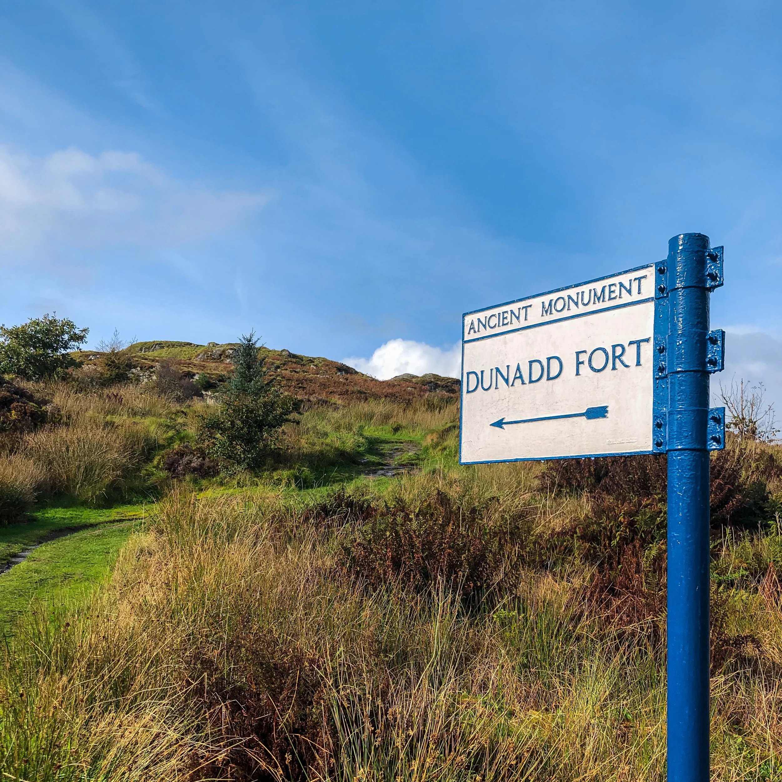 Sign saying Dunadd Fort with arrow indicating direction