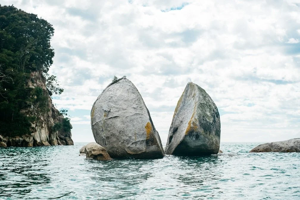 photo of split granite rock in the ocean