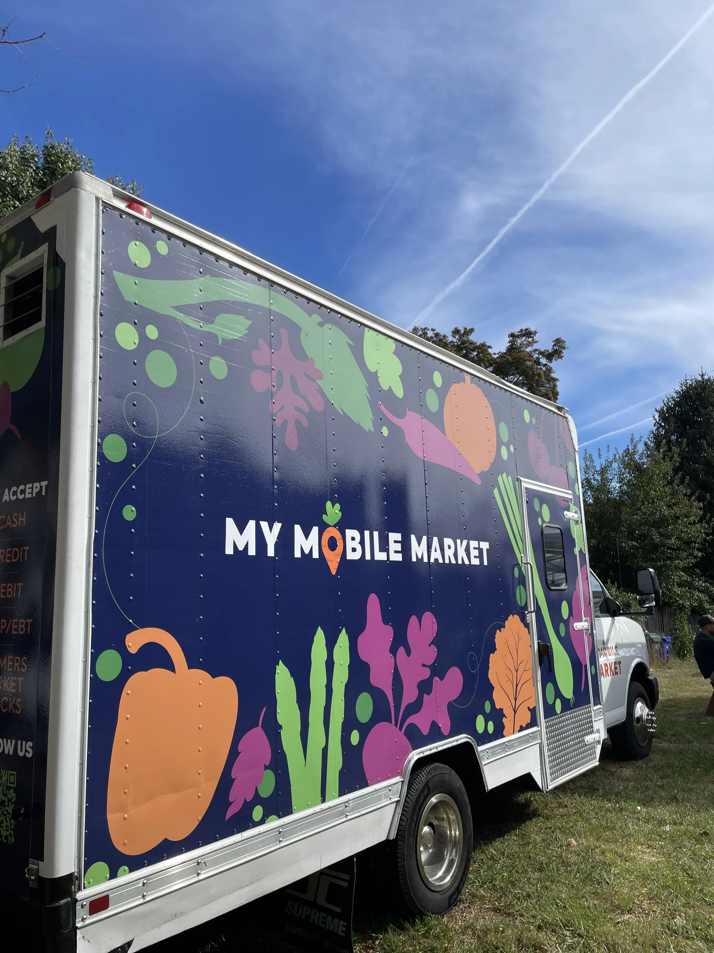 Side profile of My Mobile Market Truck wrapped in blue and vegetables