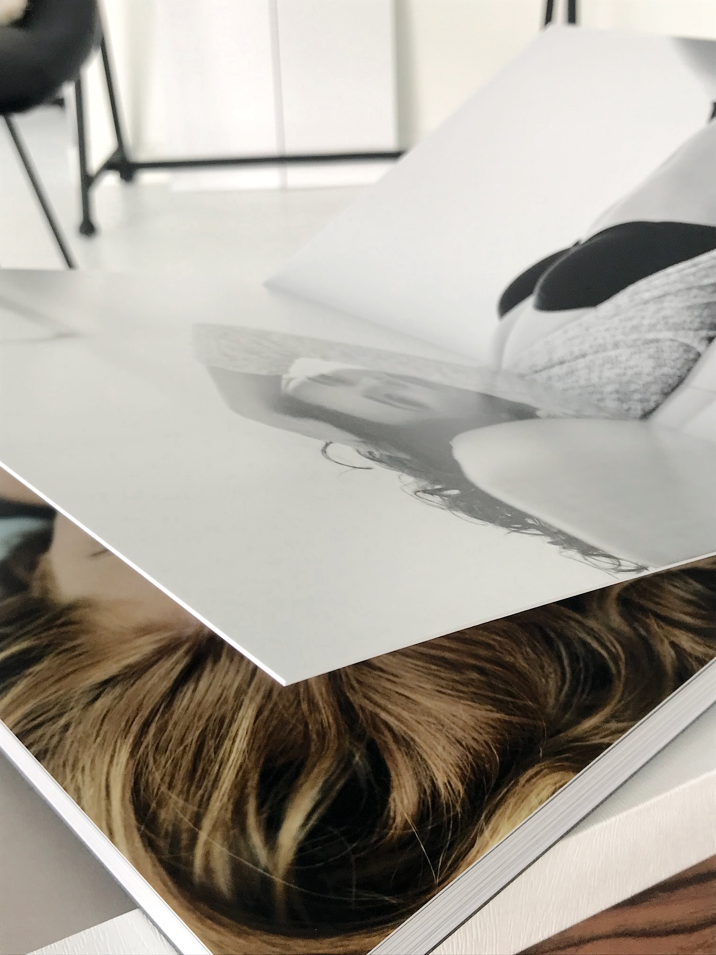 Open fashion magazine with black and white photo, close-up of pages showing a woman lying down and textured hair.