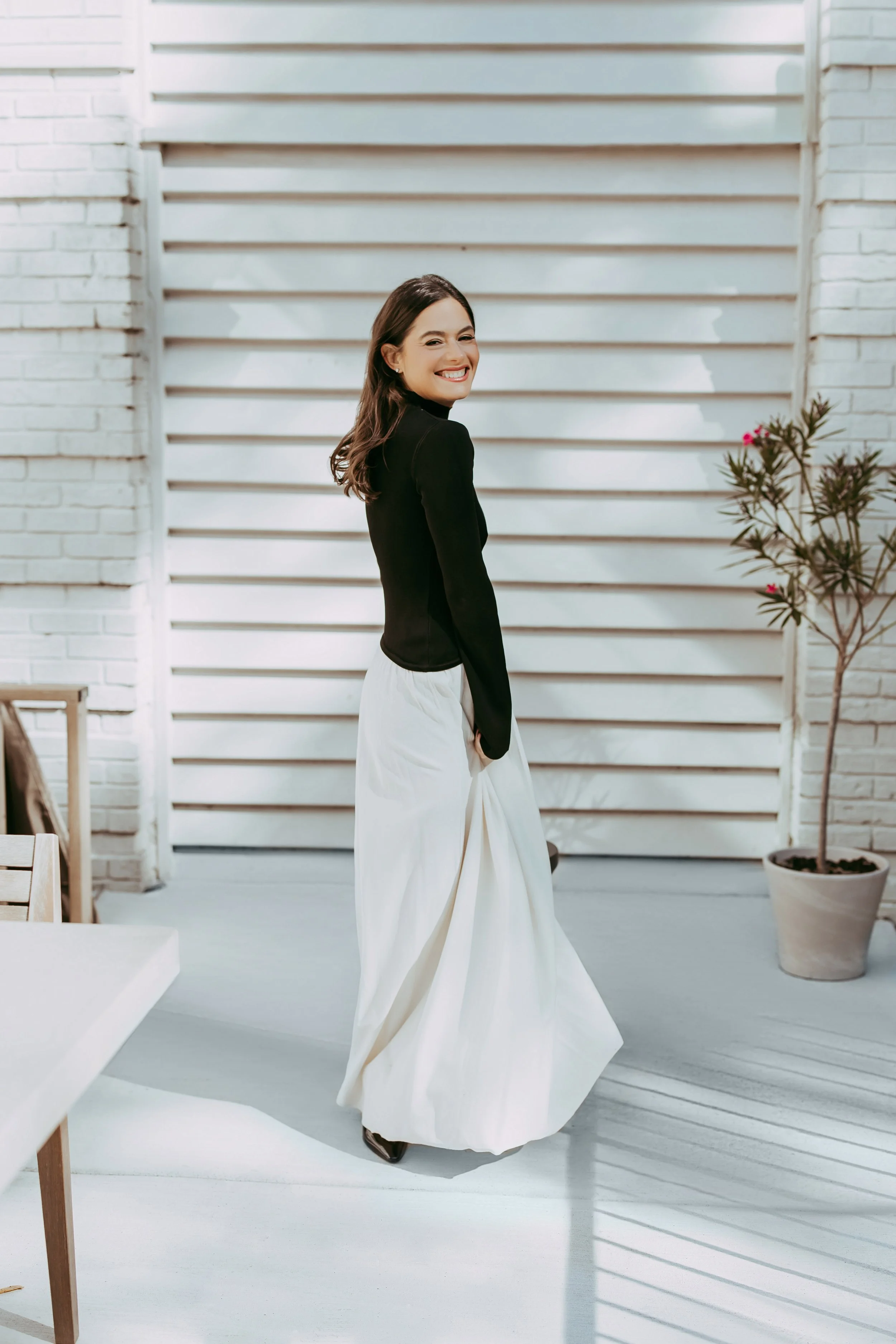 Woman smiling outdoors in flowing skirt