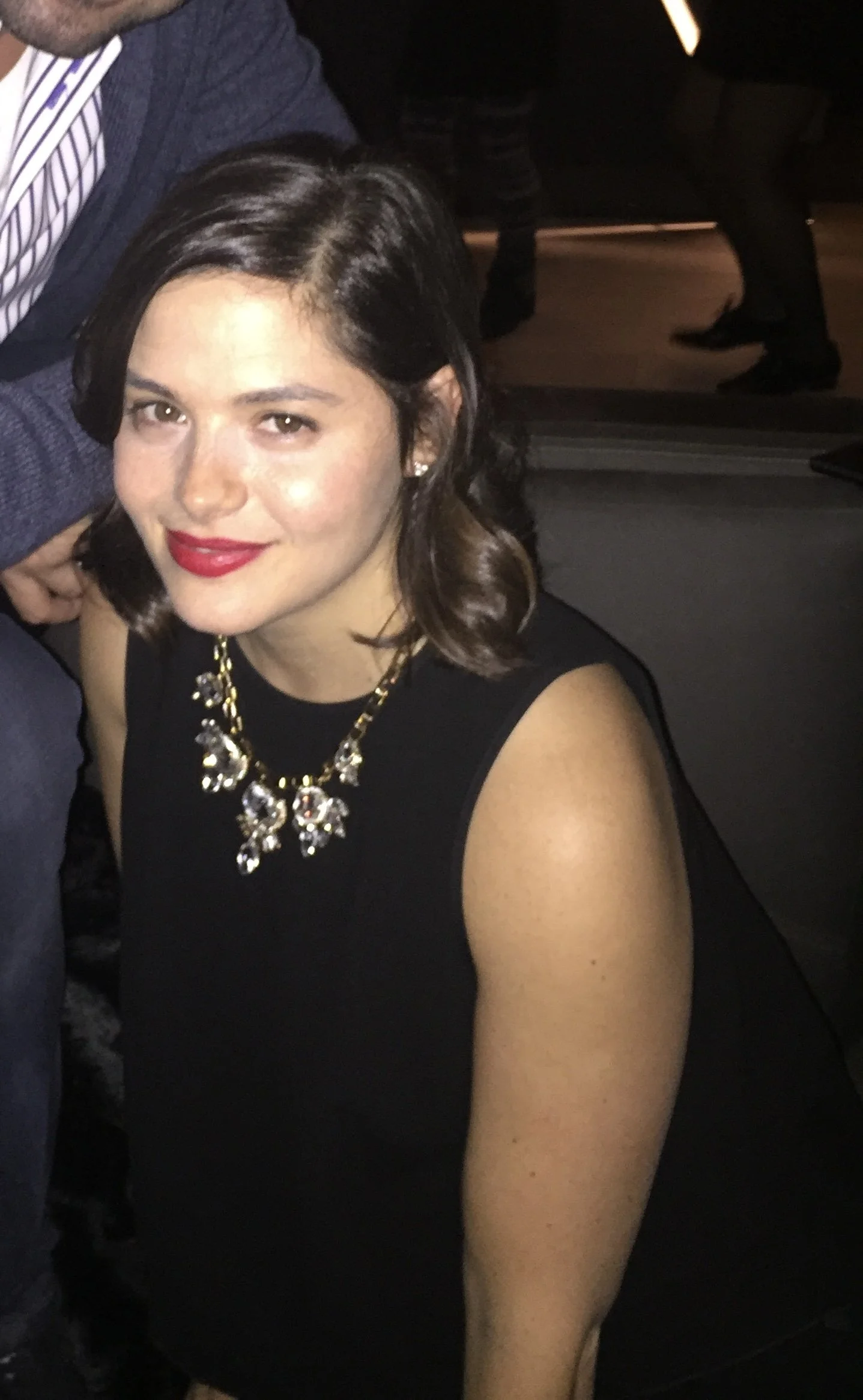 Woman smiling wearing black dress and necklace