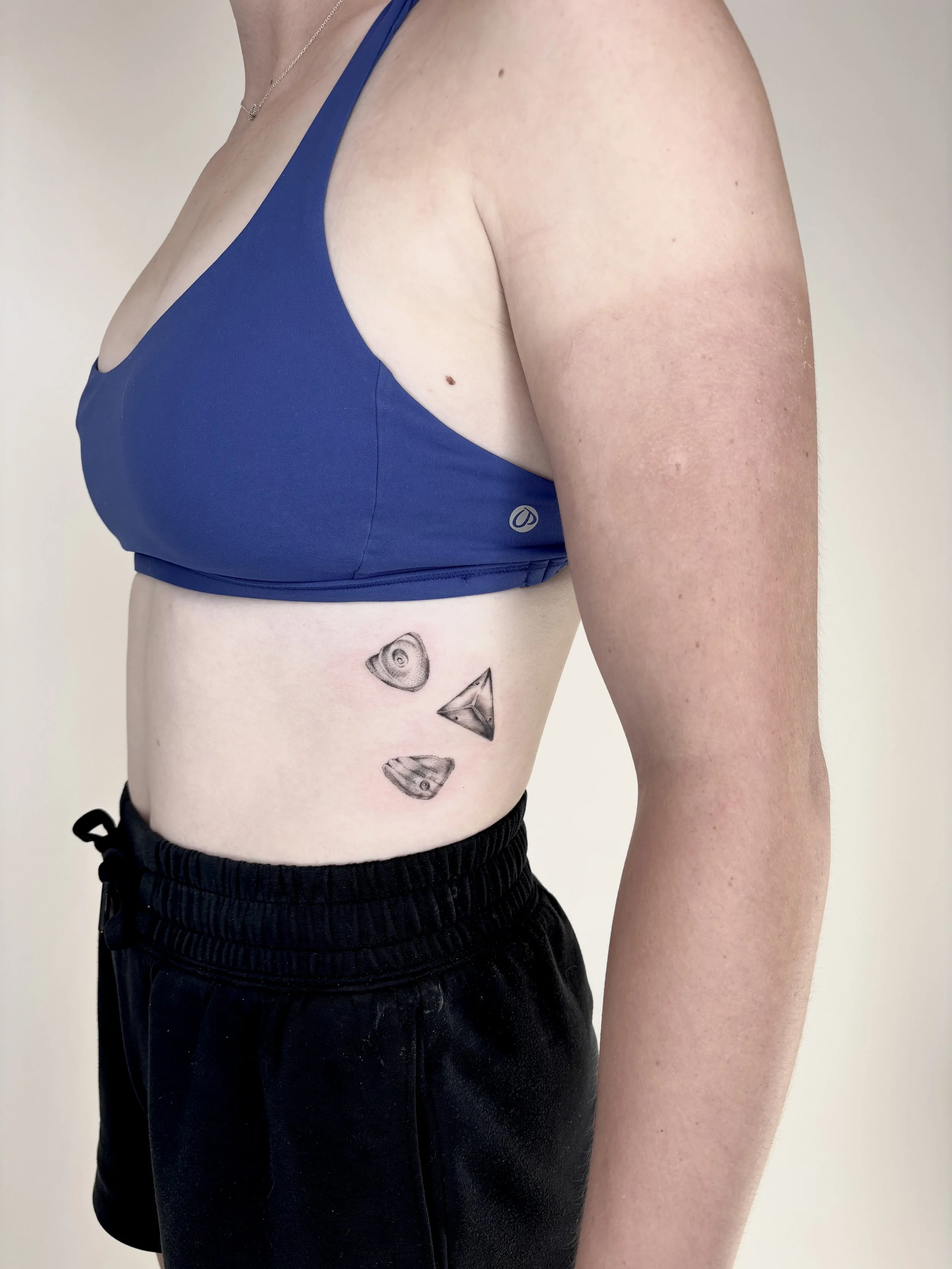 Tattoo on the ribs of rocking climbing holds.