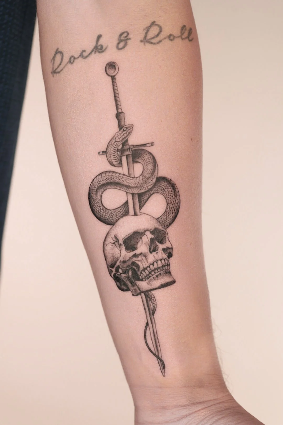 Skull and snake on a sword tattoo