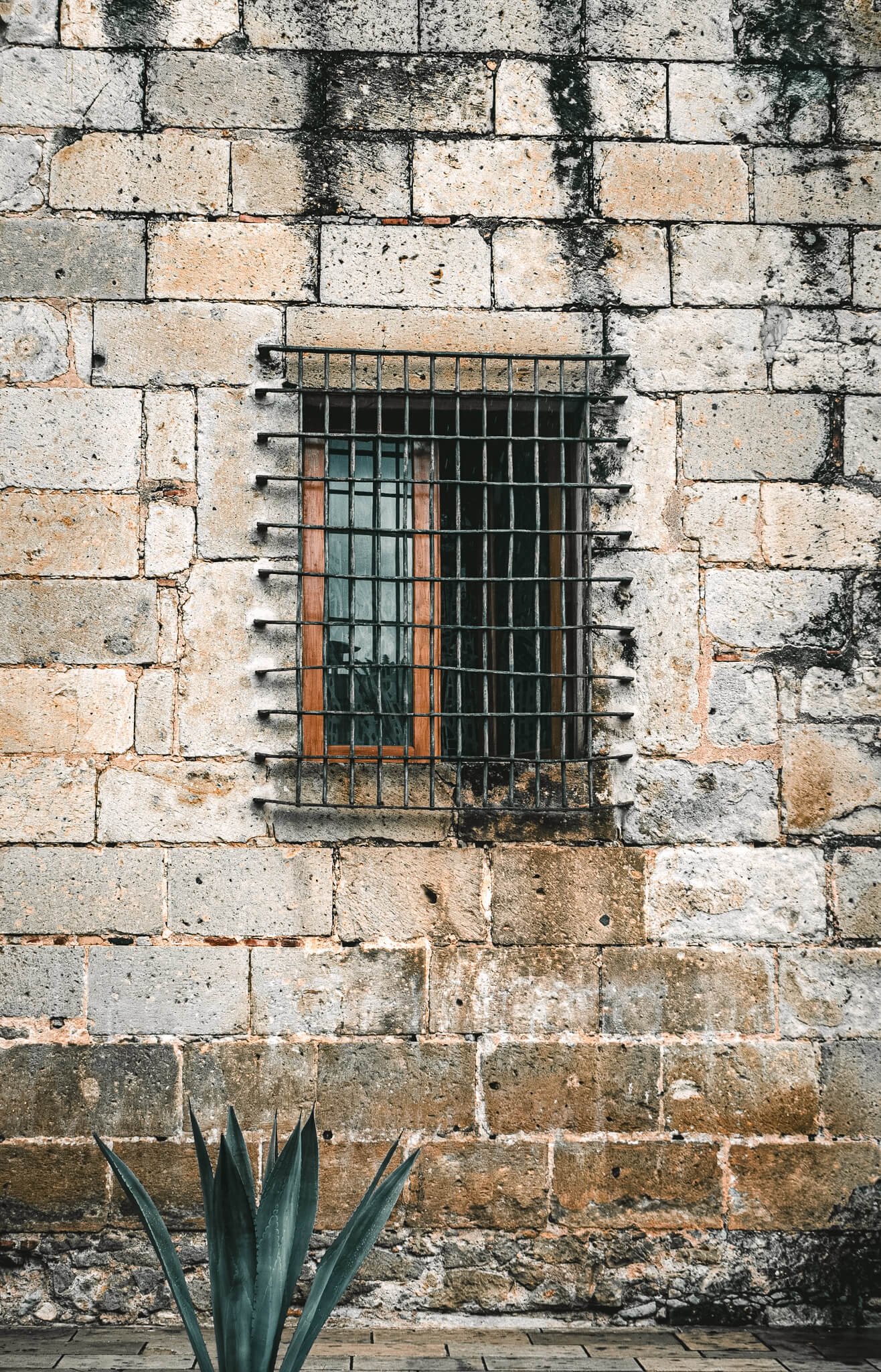 Brick wall window iron bars.