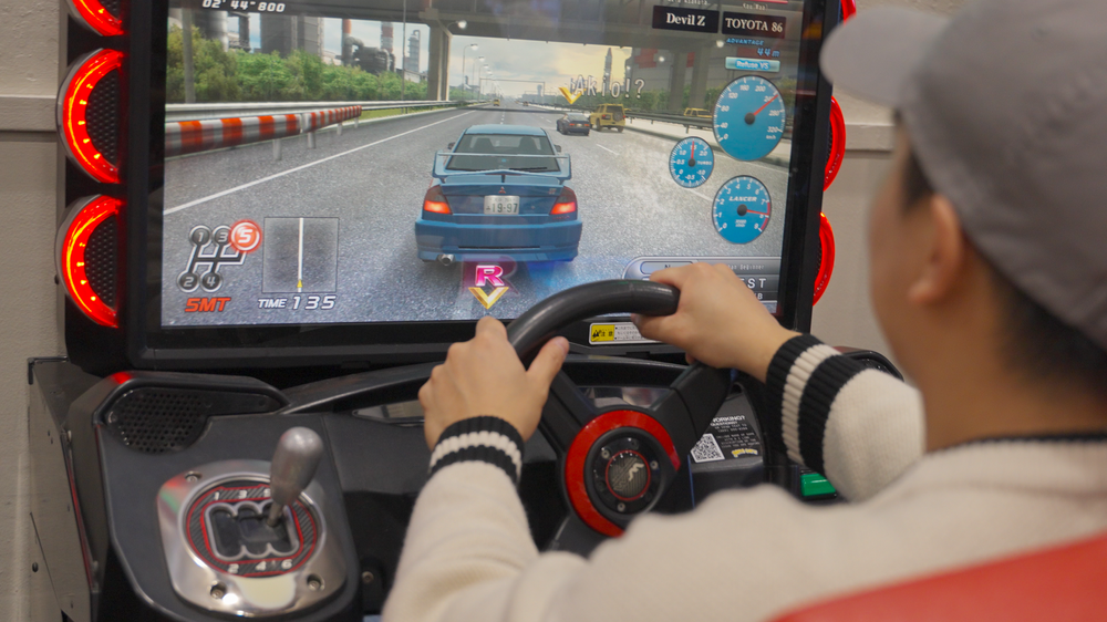 Attendee playing a racing arcade game