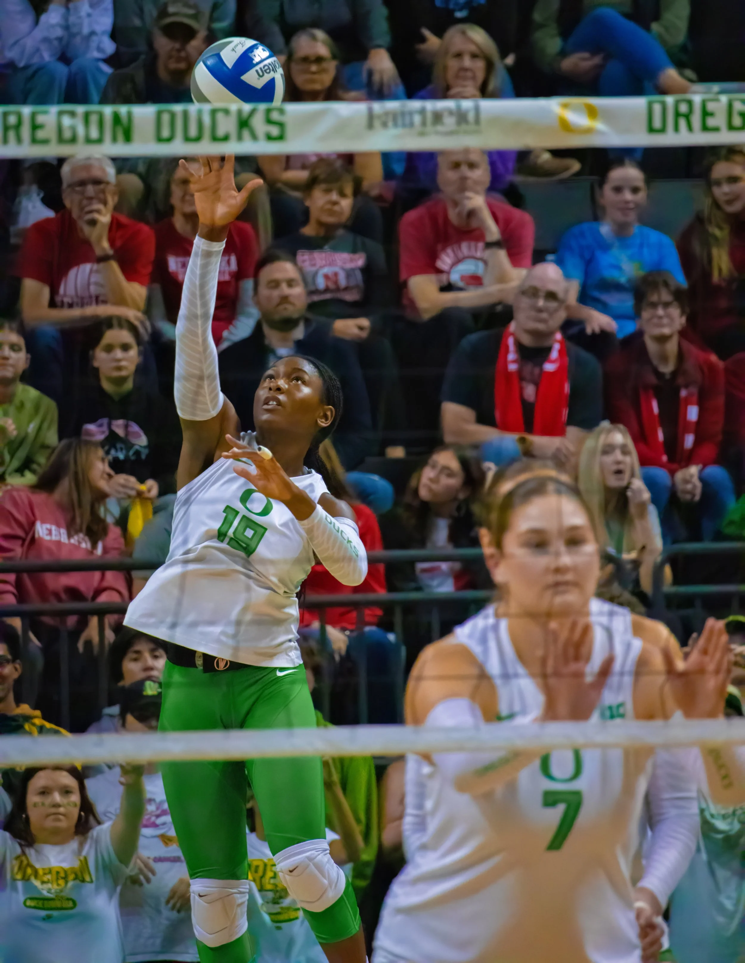 University of Oregon duck outside hitter Michelle Ohwobete, #19, jump serves ball to begin the rally. Photo by Emily Manciu