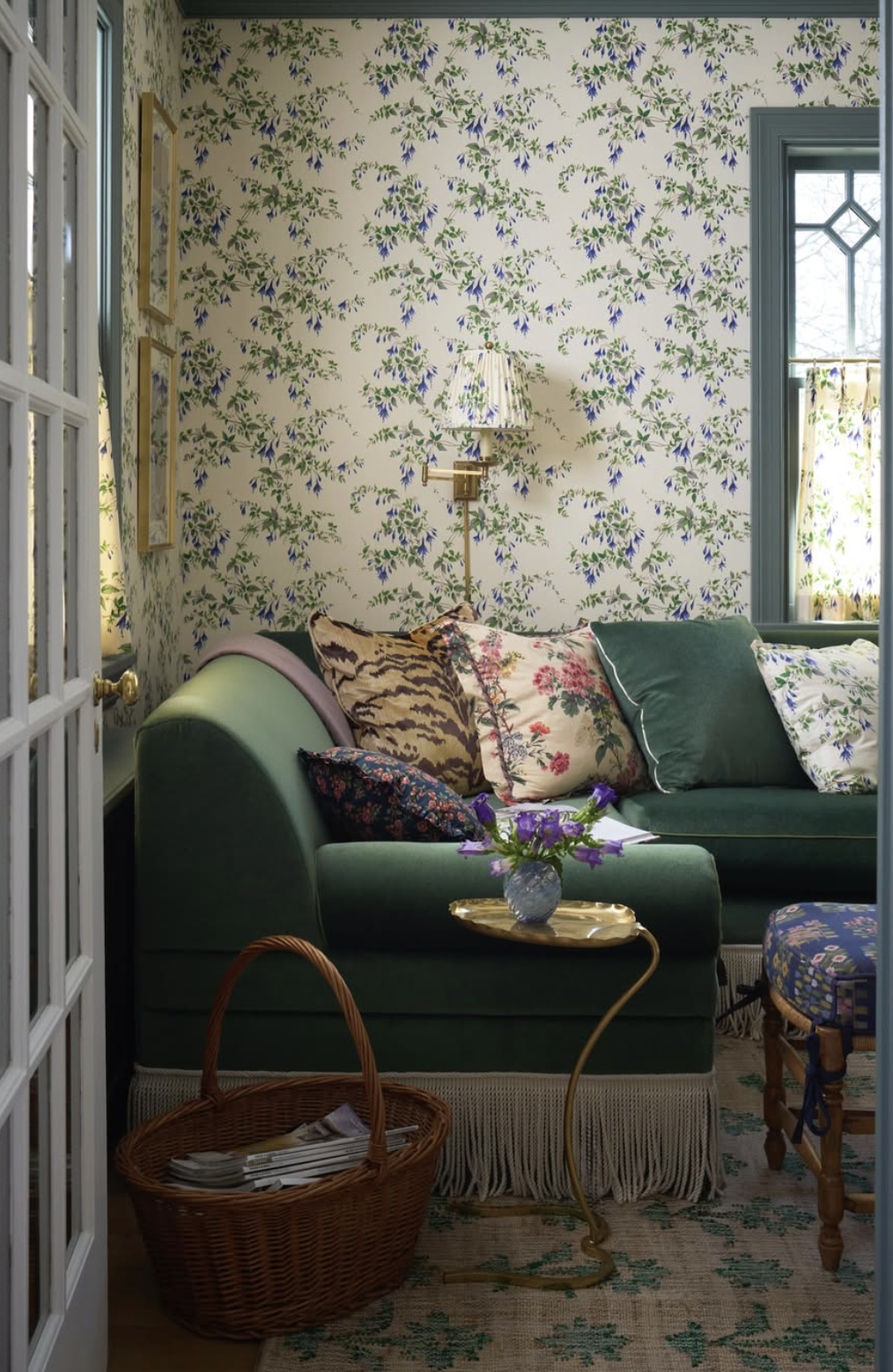 Cozy living room with patterned wallpaper, green velvet sofa with floral and animal print pillows created by Jenny Holladay of Jenny Holladay Design in Richmond, VA.