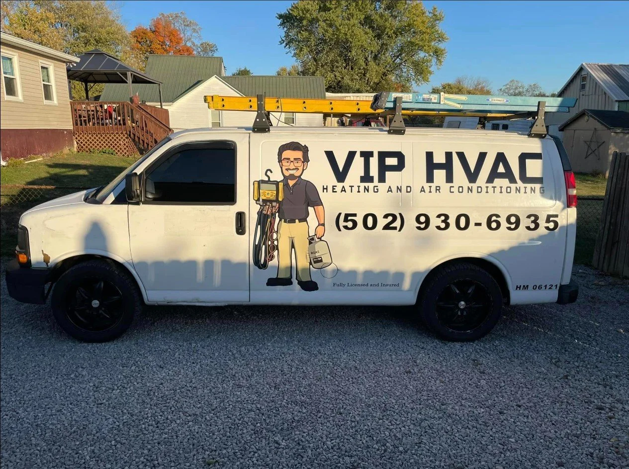 Side of a white van advertising VIP HVAC heating and air conditioning services, with a cartoon man holding HVAC tools, the company's phone number, and a roof ladder on top.