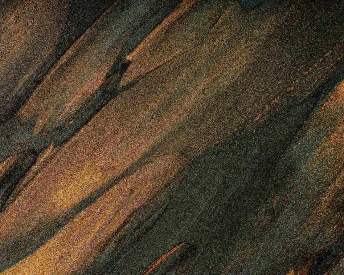 Abstract textured surface in dark amber and stone, reflecting depth, foundation and long-term strategic thinking.