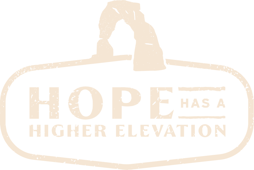 A sign with the famous rock formation, the Gateway Arch, above the words "Hope Has a Higher Elevation" in white text on a black background.
