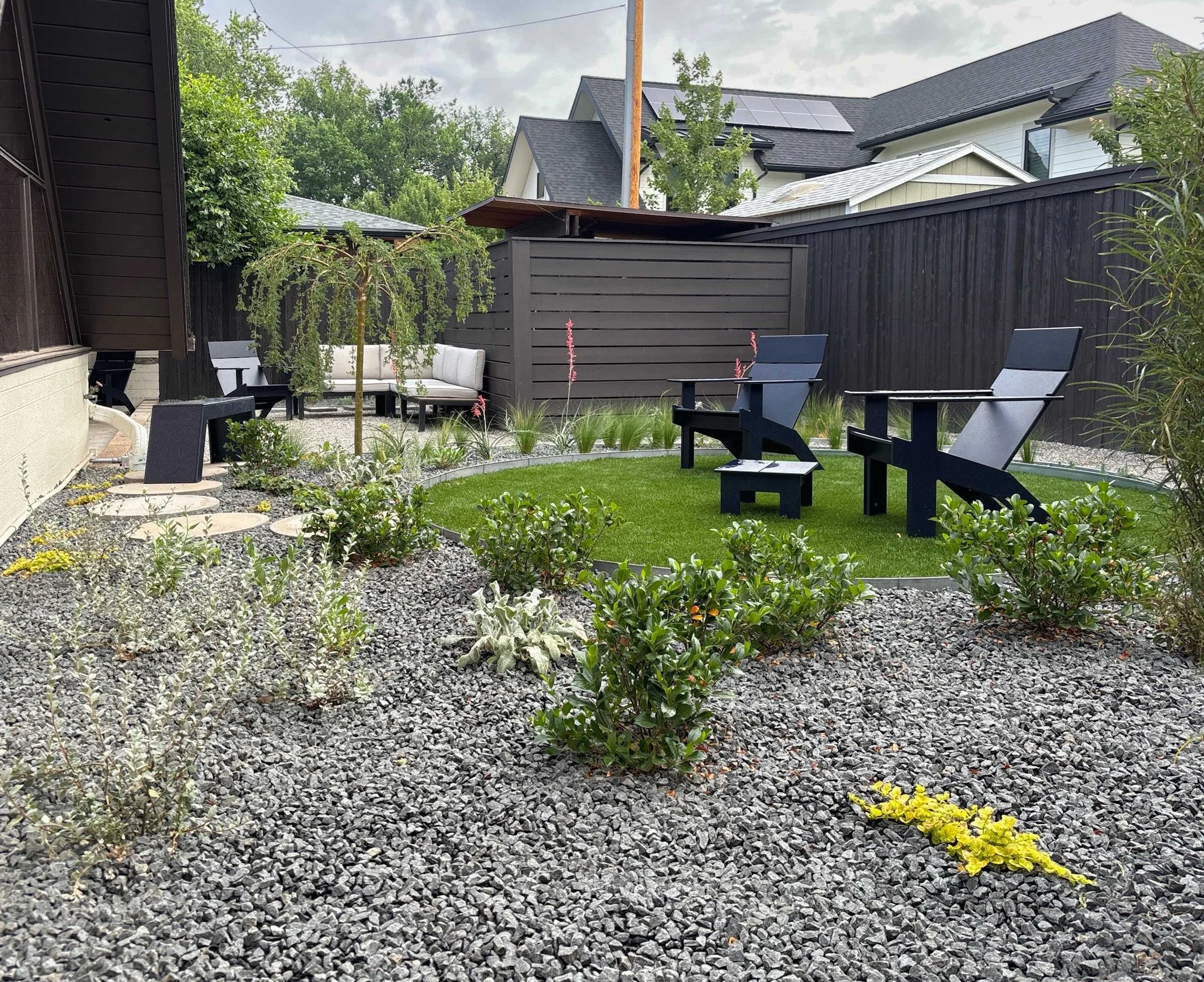 Contemporary gravel garden with seating and plantings, designed by The Green Fuse for low-maintenance outdoor living.