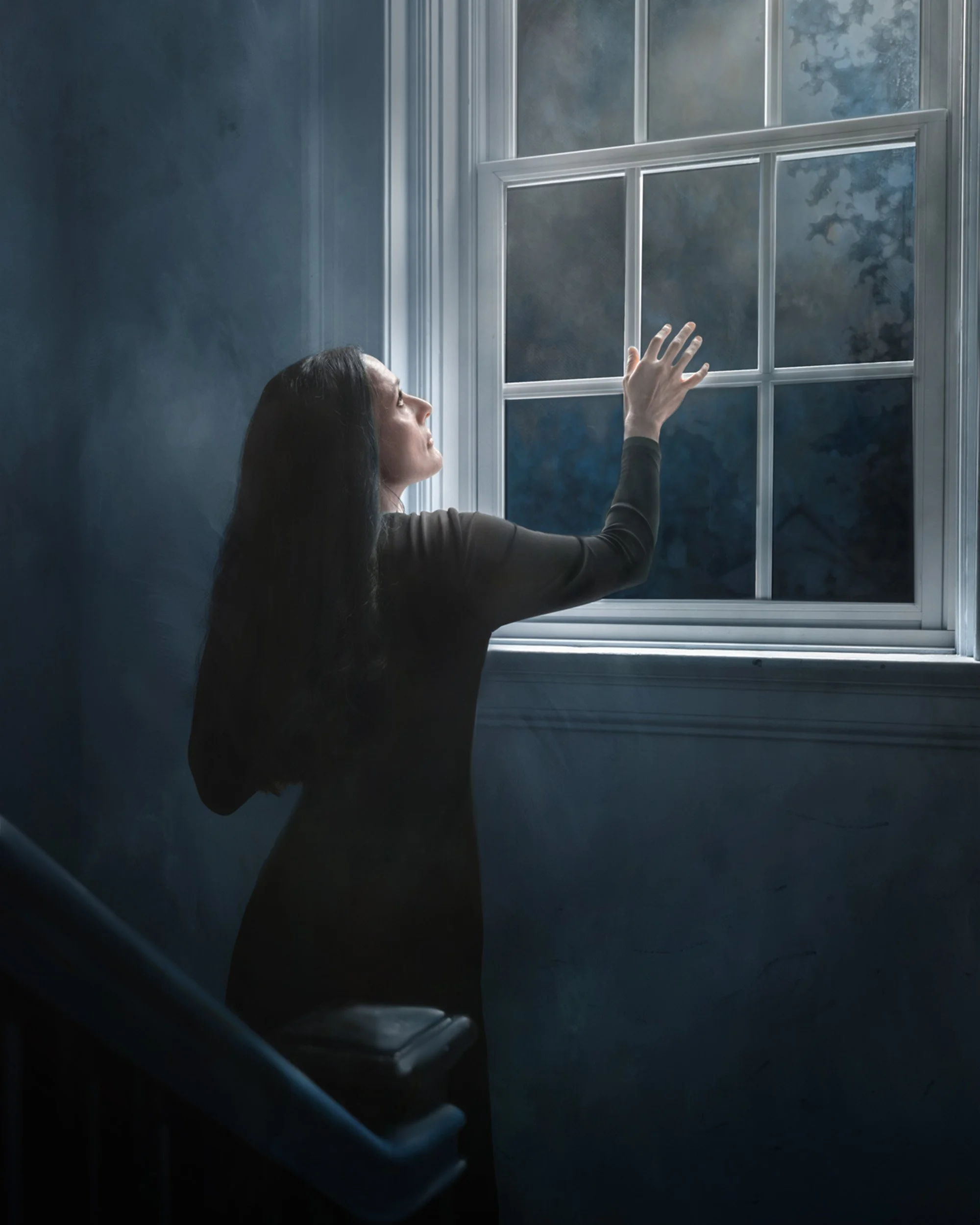 Woman in blue gazing out the window