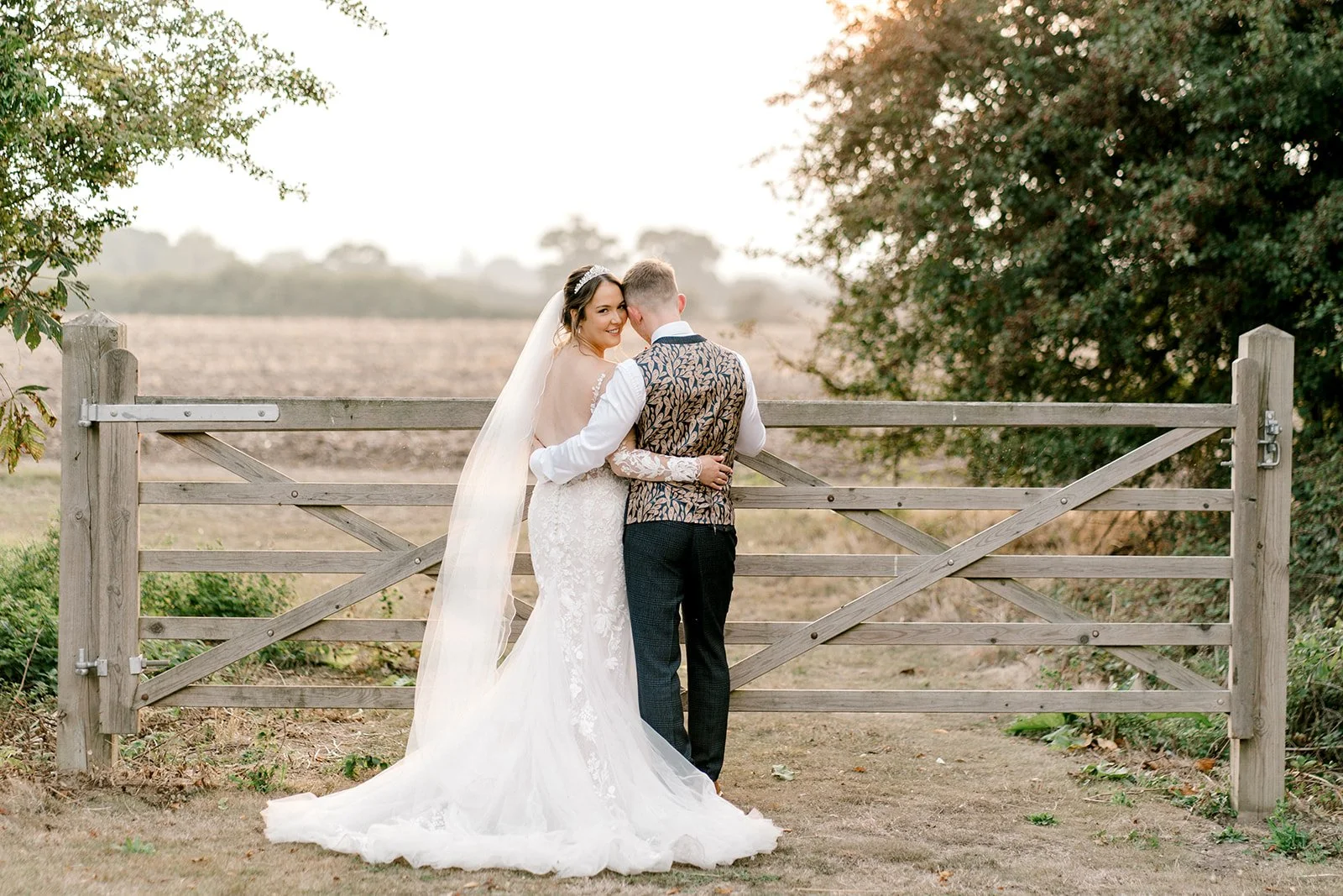 bride and groom countryside sunset portraits in the fields at apton hall captured by laura jane photography