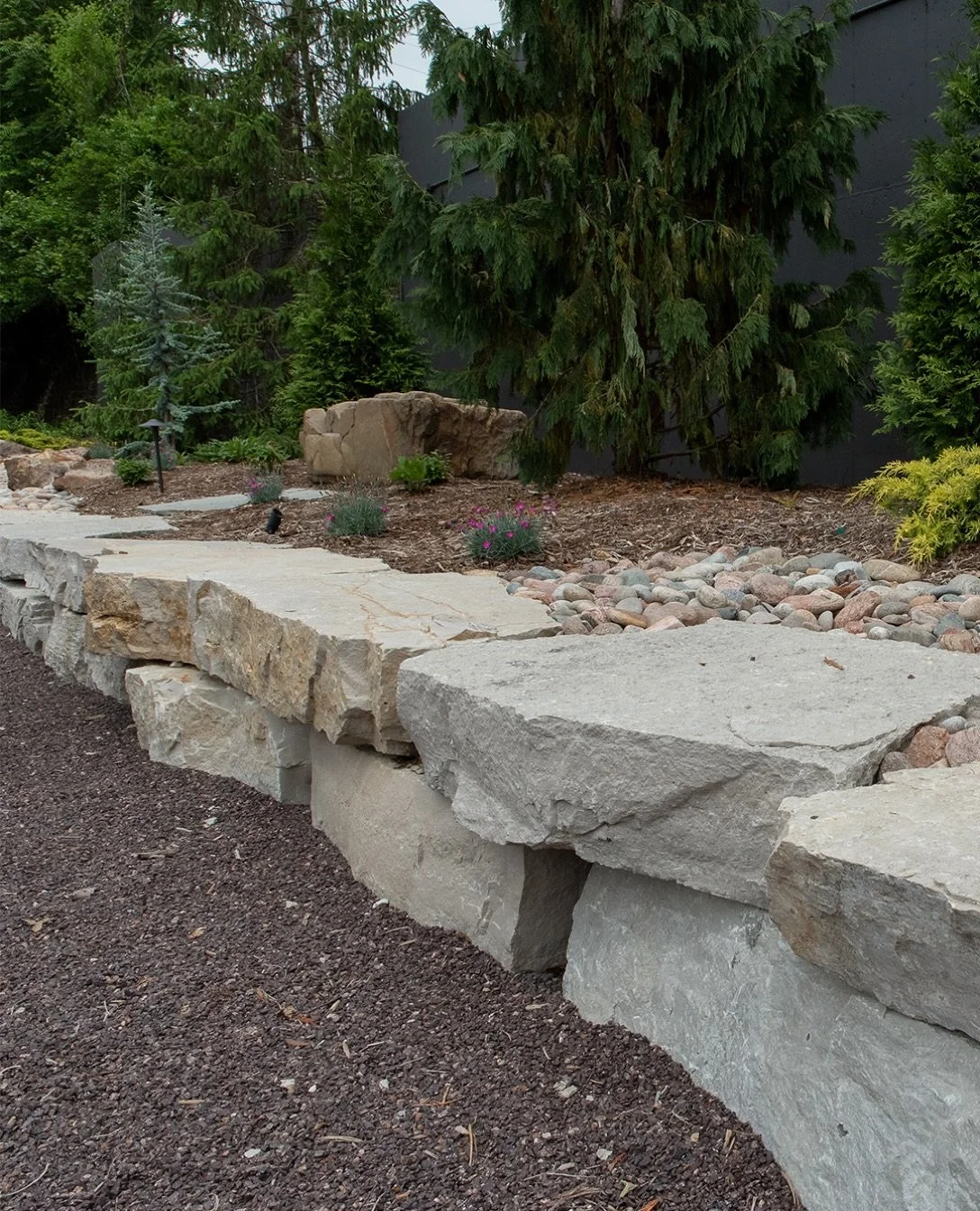 Whether retaining an area or creating a visual perimeter, stone outcropping can bring massive interest to your outdoor living space. These large, irregular slabs of limestone can also be used to create water features, natural steps and more. Peeping 
