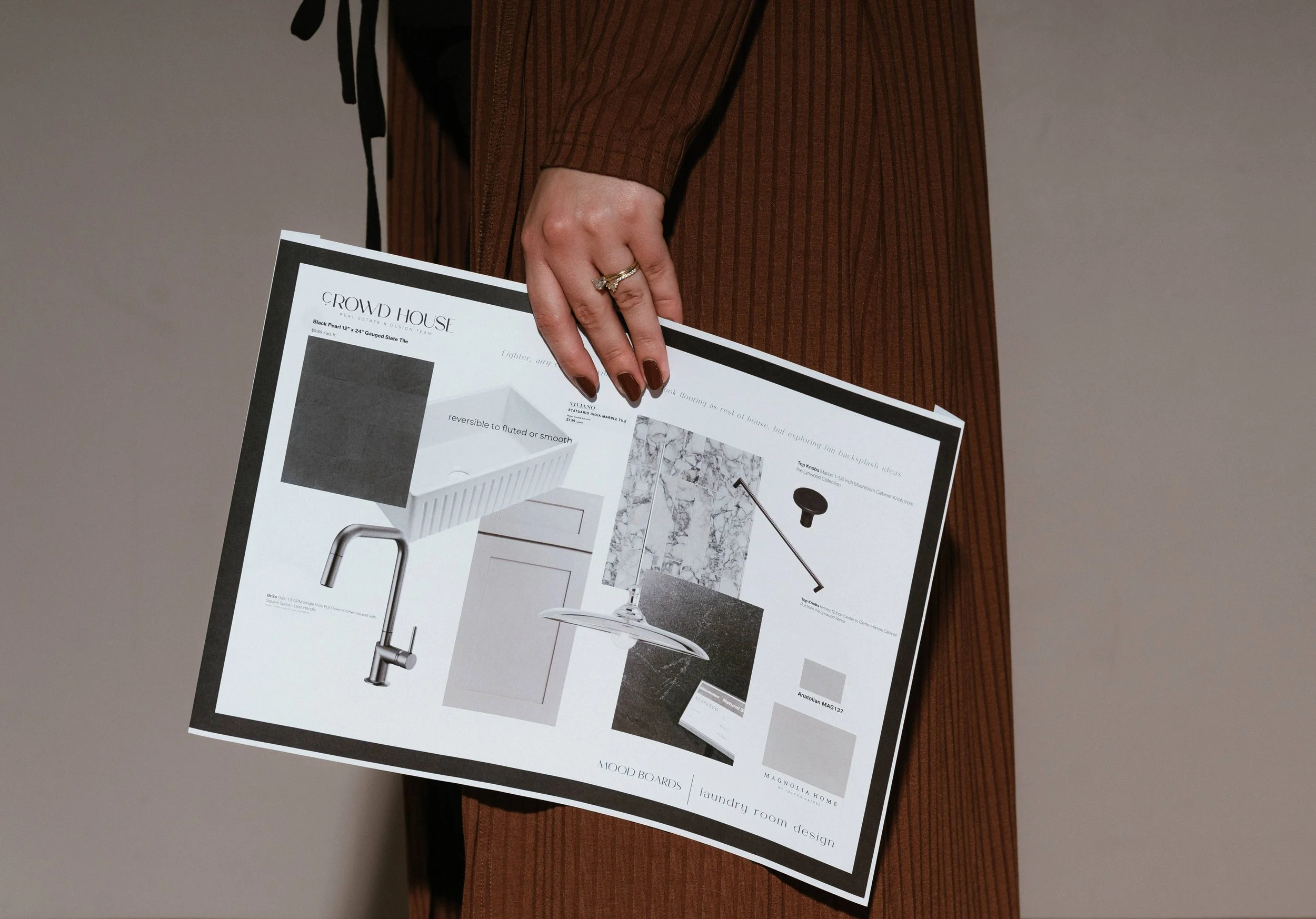 A woman holding a print out of an interior design moodboard.