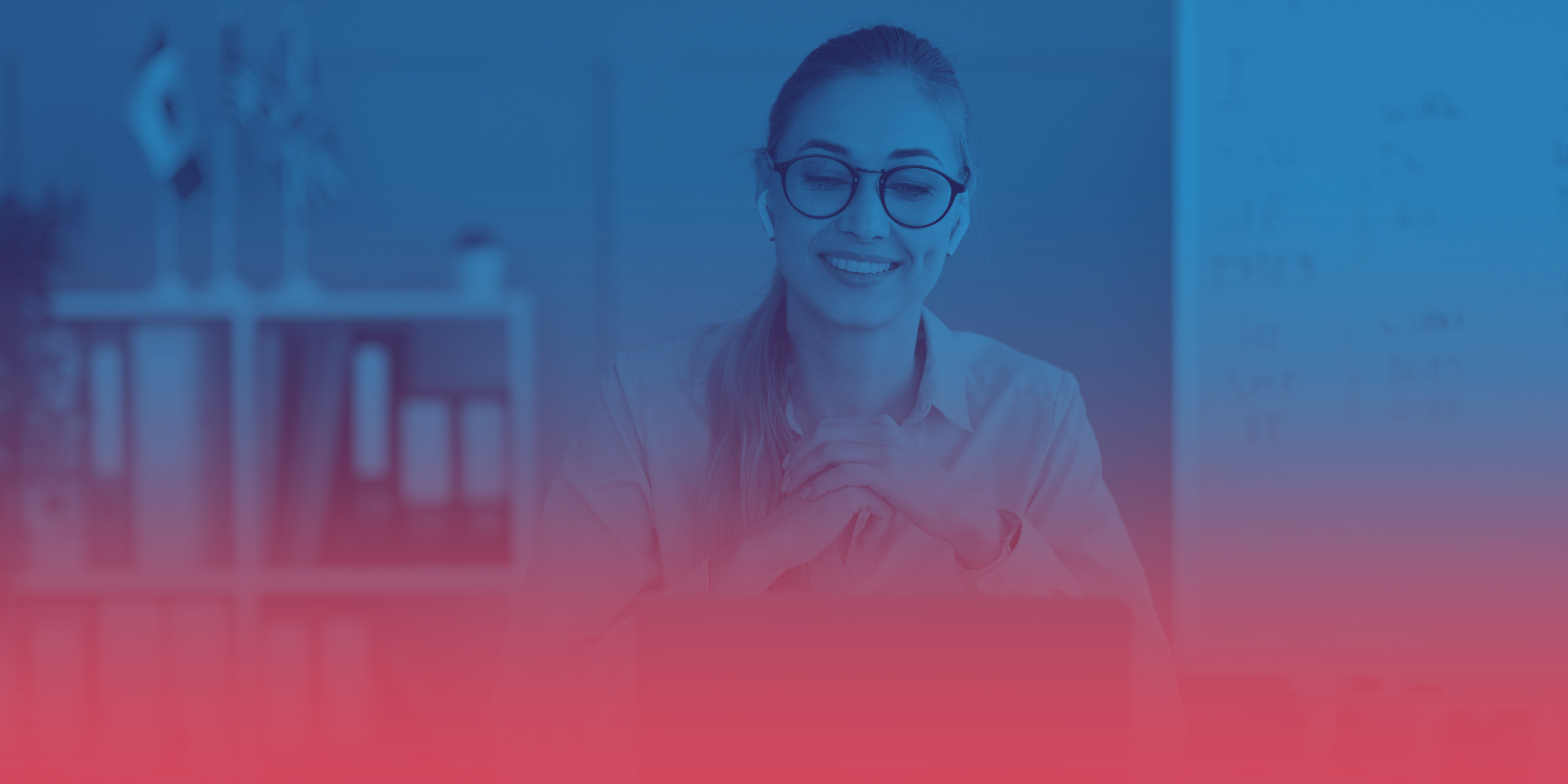 A woman with blonde hair wearing glasses and wireless earbuds, smiling with hands clasped, sitting in an office or classroom setting.