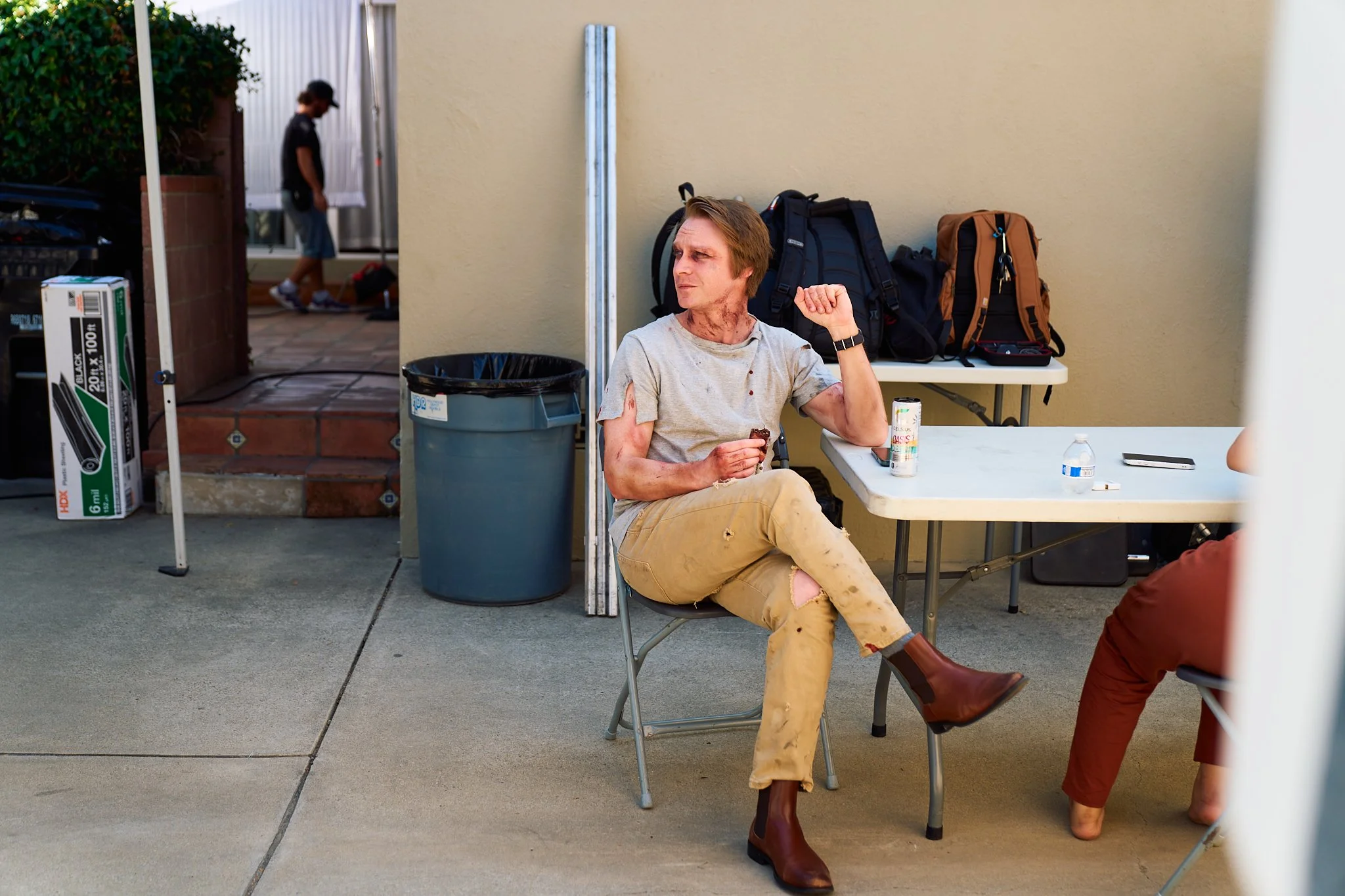 Unit stills photography, for the short film TEDDY, BTS image of actor Calum Worthy sitting on set.