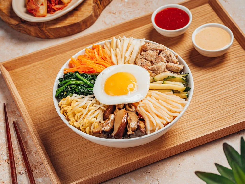 Doraji chicken bibimbap with seasoned vegetables and a fried egg