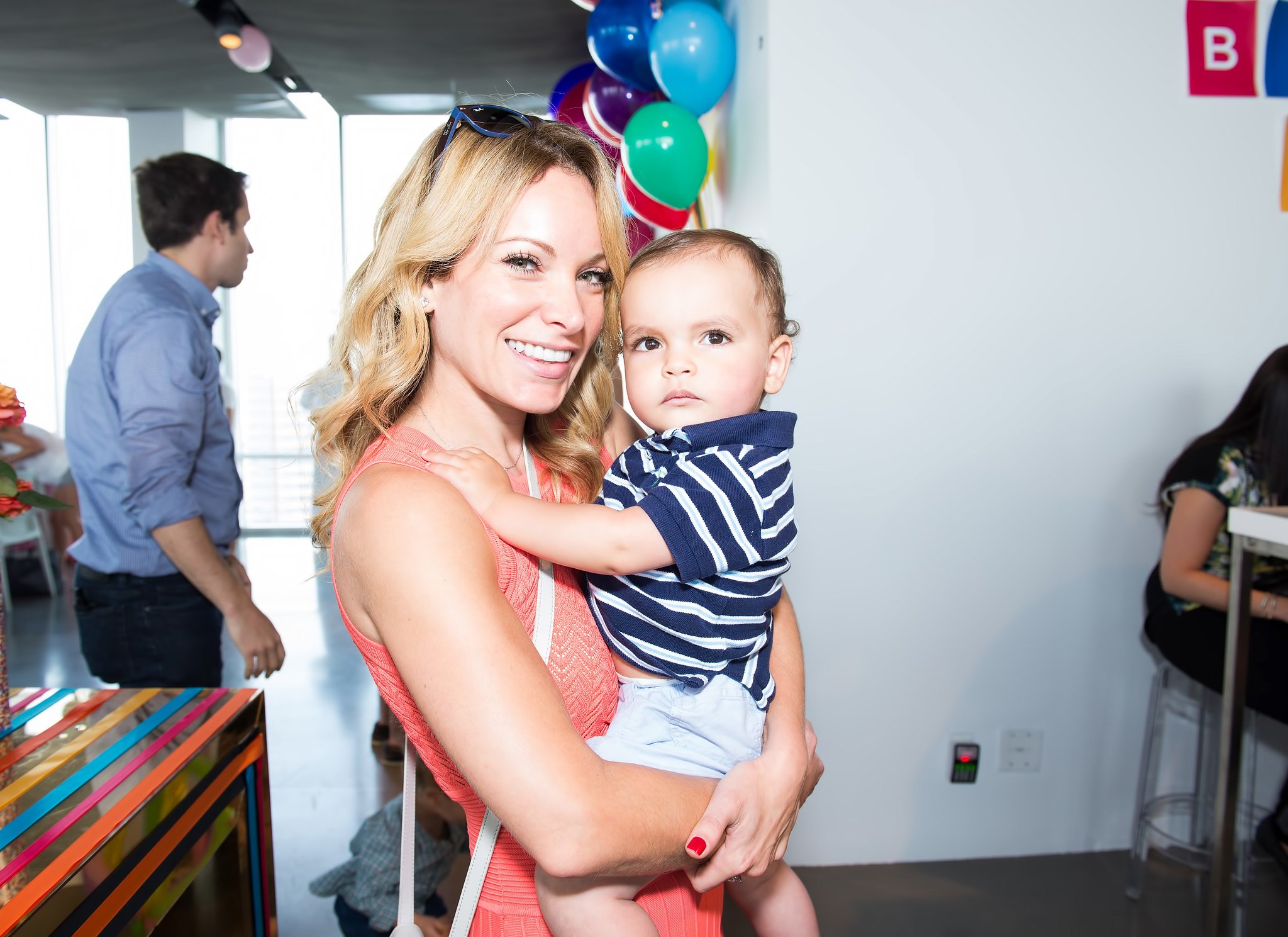 Woman holding son at a first birthday party hosted by Lee Fixel 
