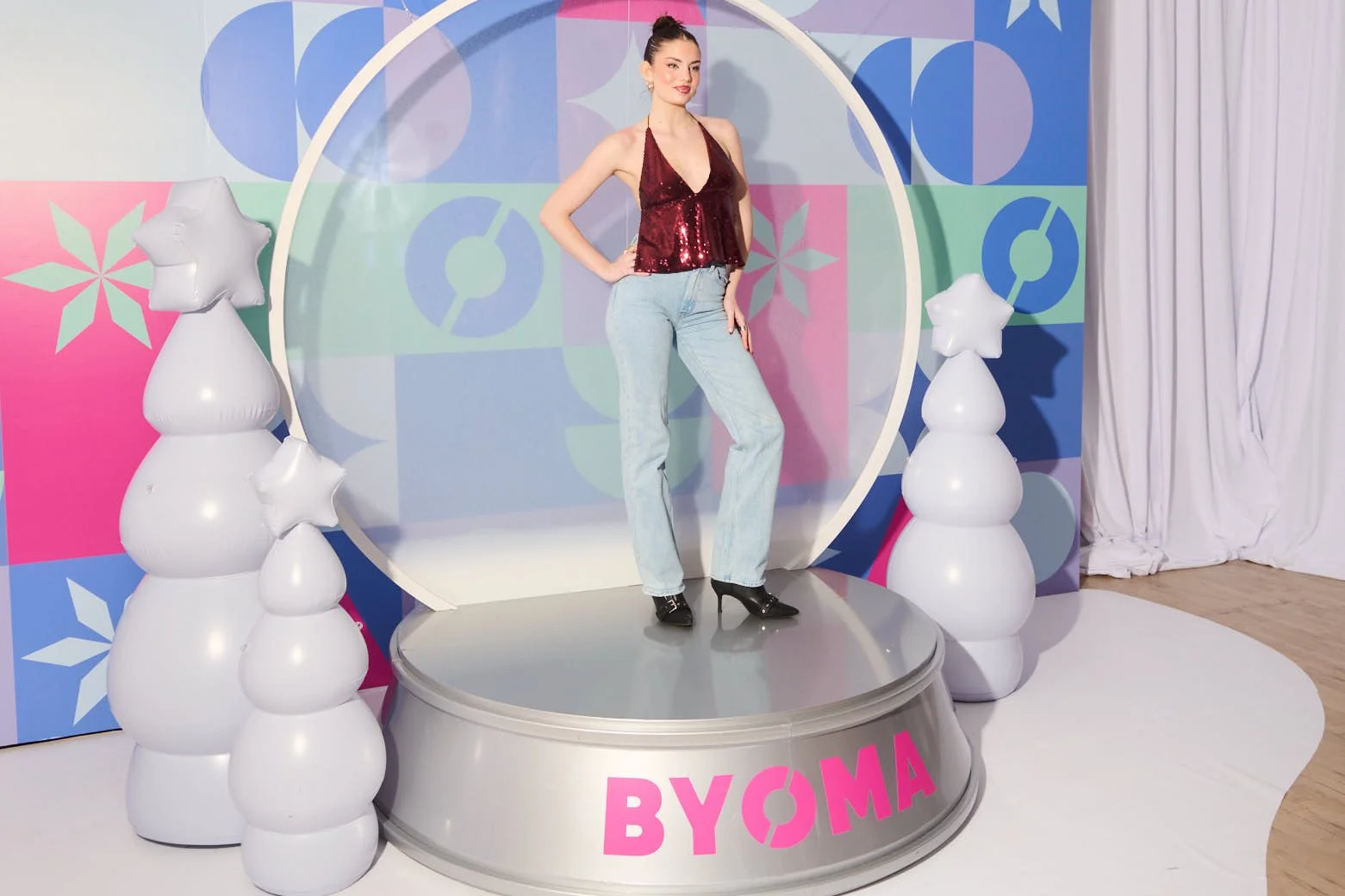 A woman posing on a stage prop for Byoma Skincare