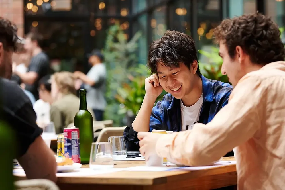 Young man smiling at an event hosted by A16Z