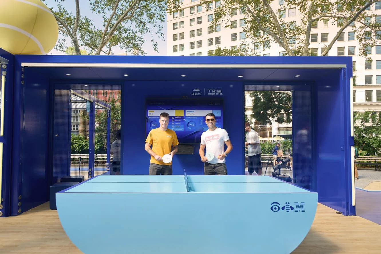 Two people posing for a photo at ibm's spacecube installation in Madison square park 