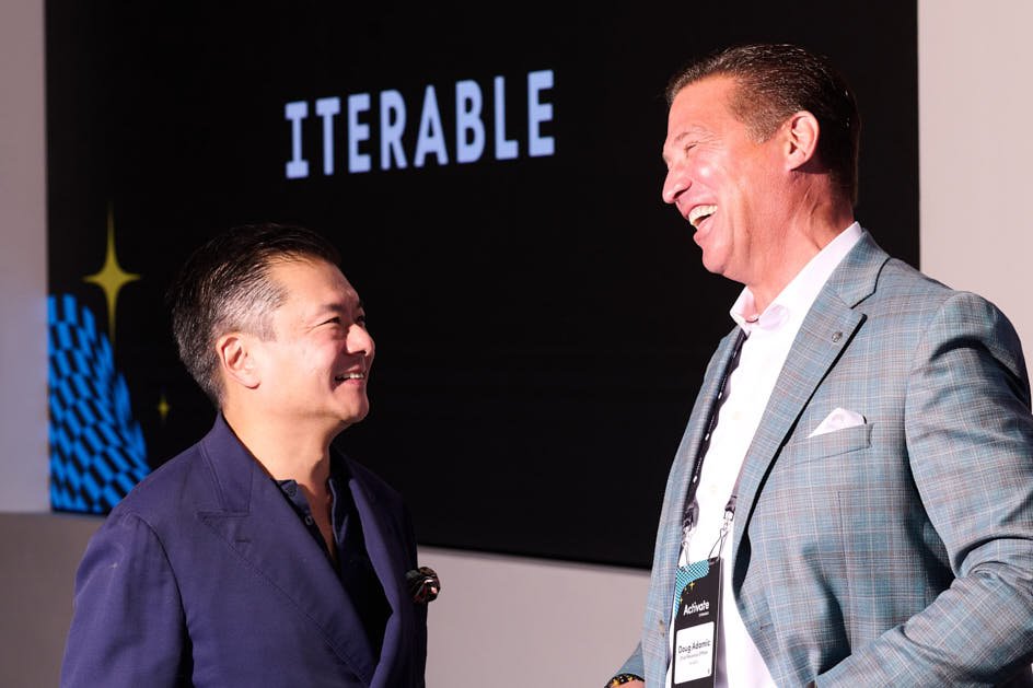 Will Lee onstage at Iterable's Activate 2025 adweek conference, laughing with an iterable executive 