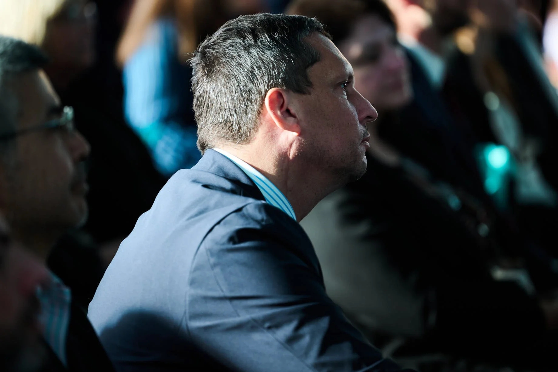 Man in crowd at nasdaq looking engaged