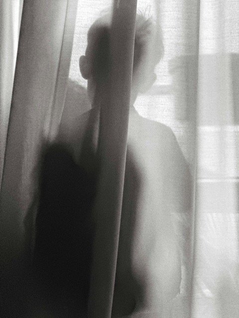 "Silhouette d'enfant isolé près d'une fenêtre, illustration du harcèlement scolaire"