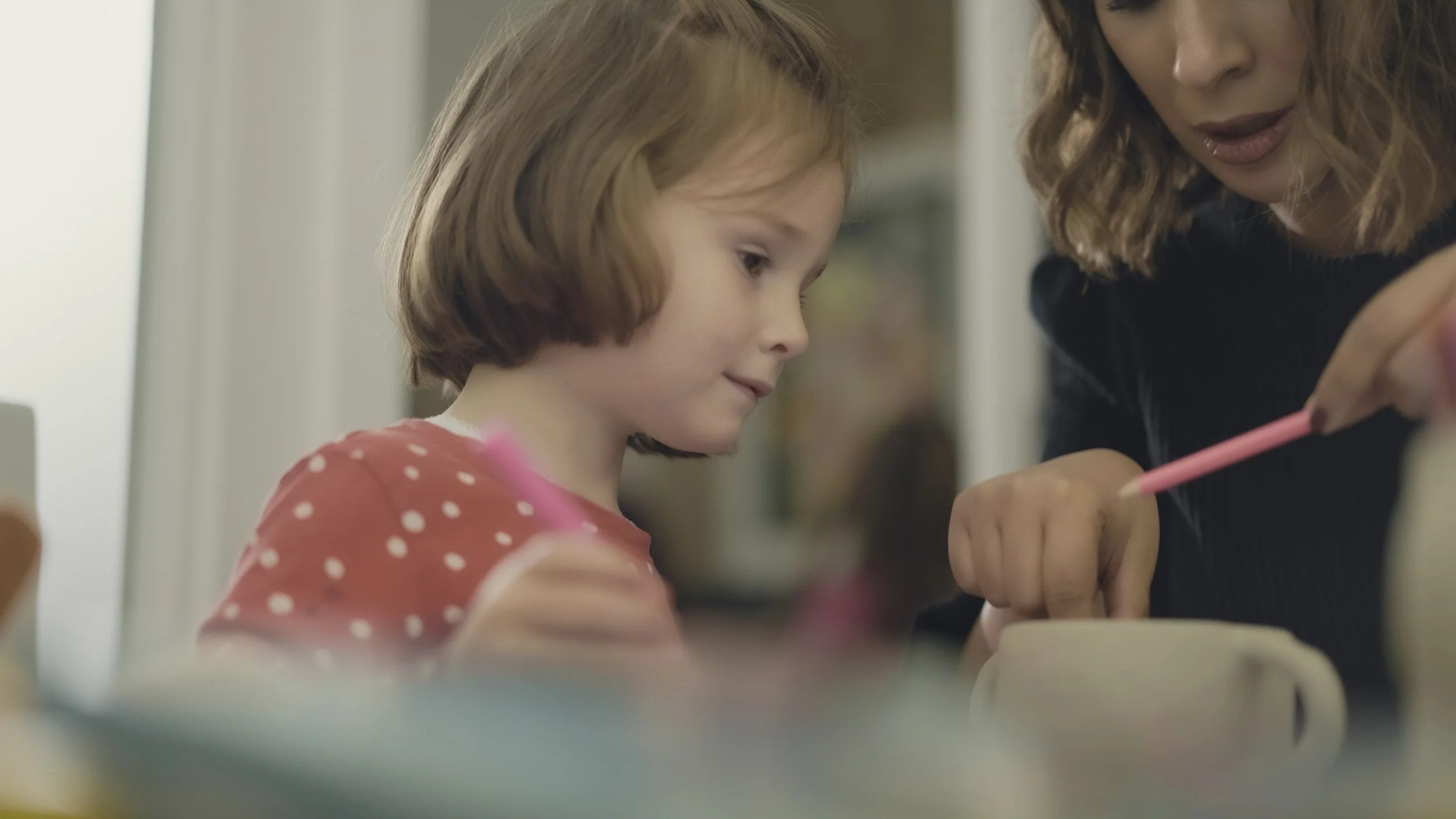 A child using creative materials with an adult.